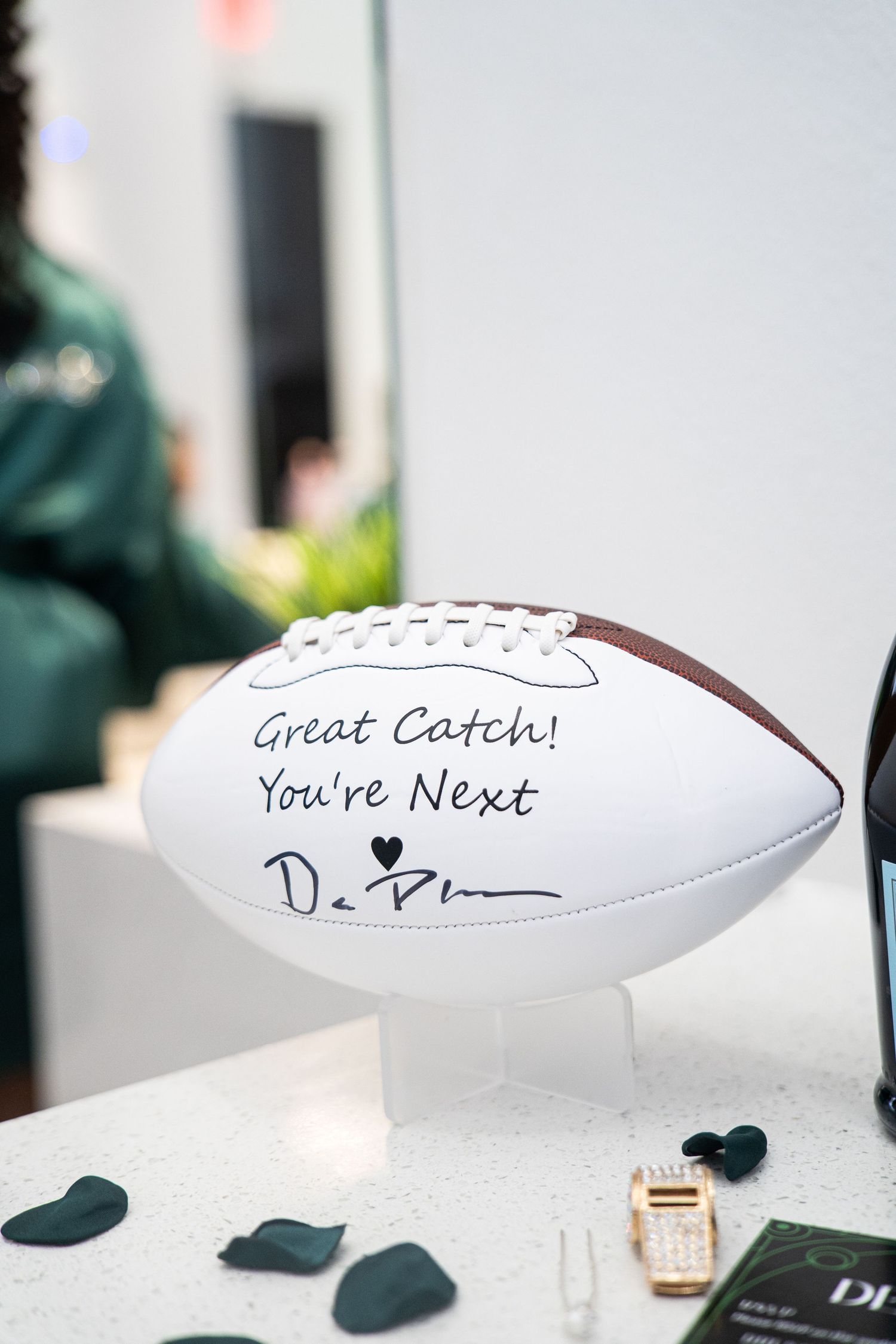 White football with handwritten message 'Great Catch' and 'You're Next' displayed as wedding decor.