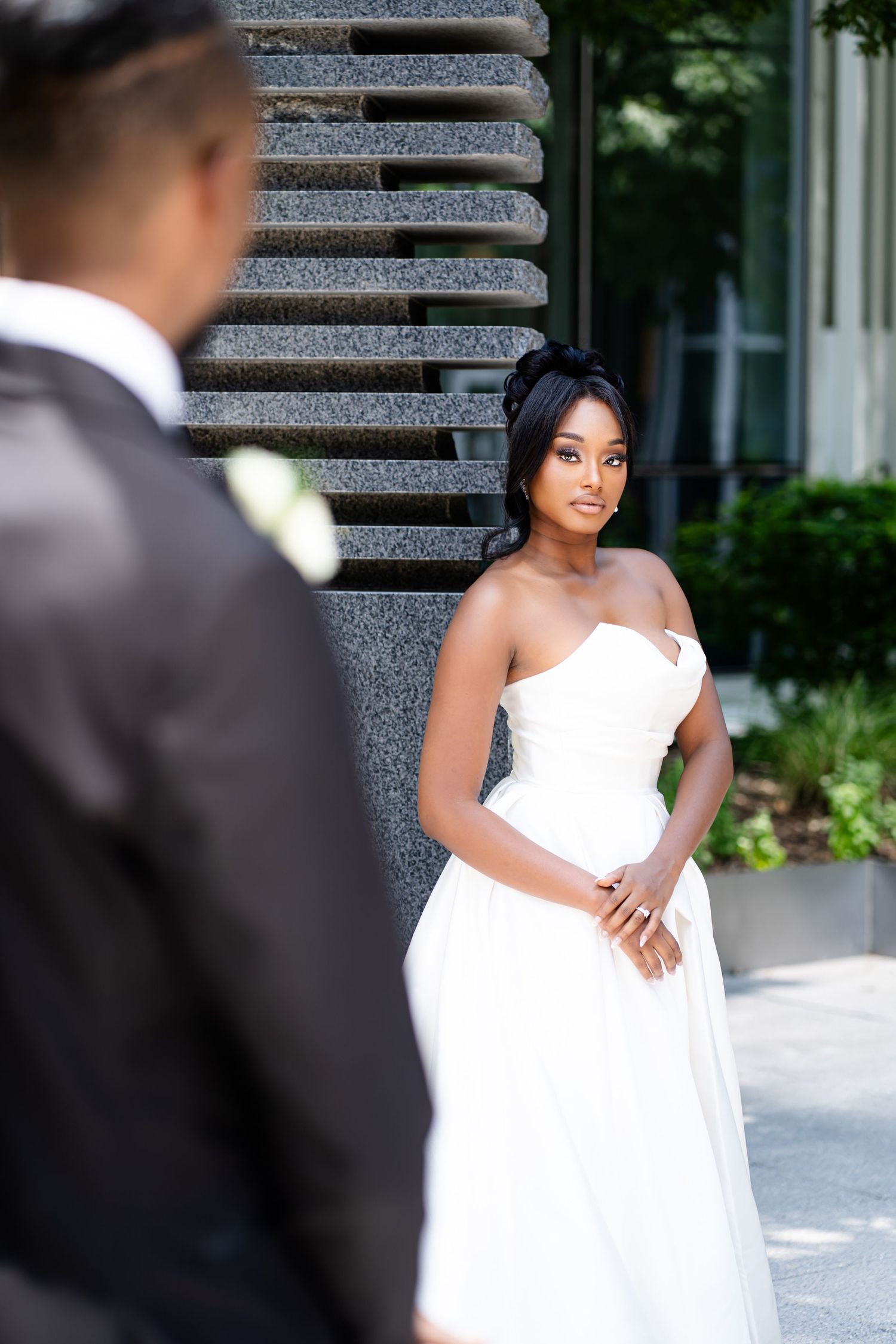 Wedding photoshoot featuring a white gown against modern architecture.