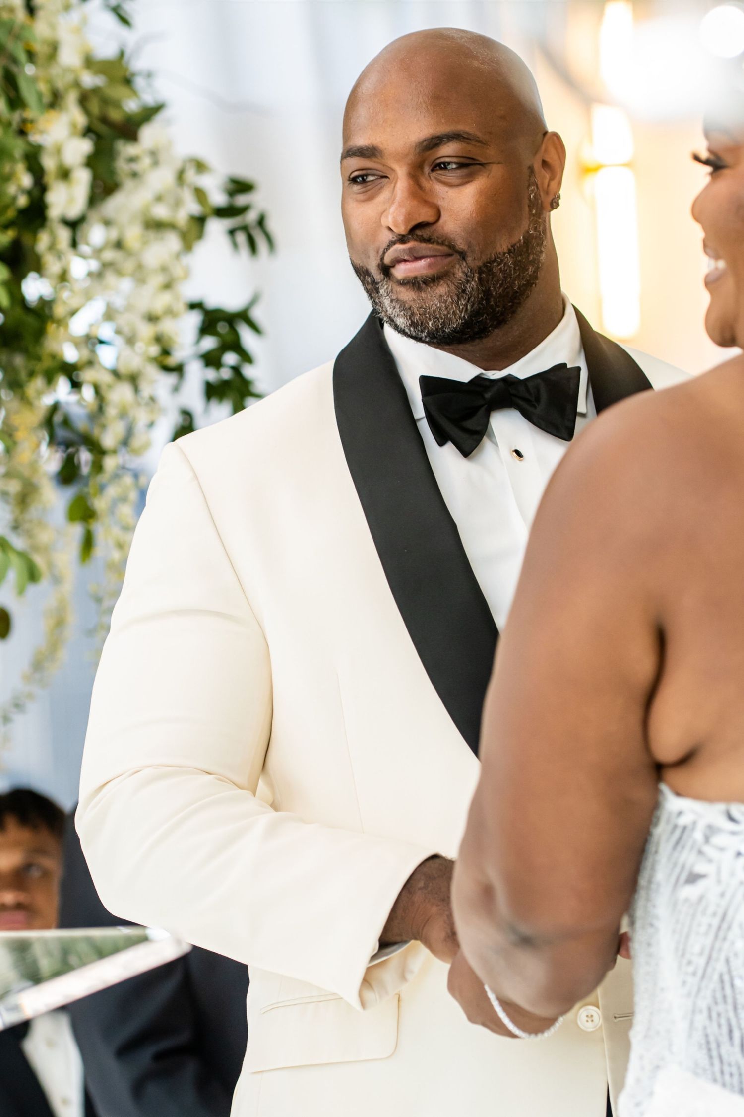 Wedding ceremony moments captured with elegant floral decor in the background.