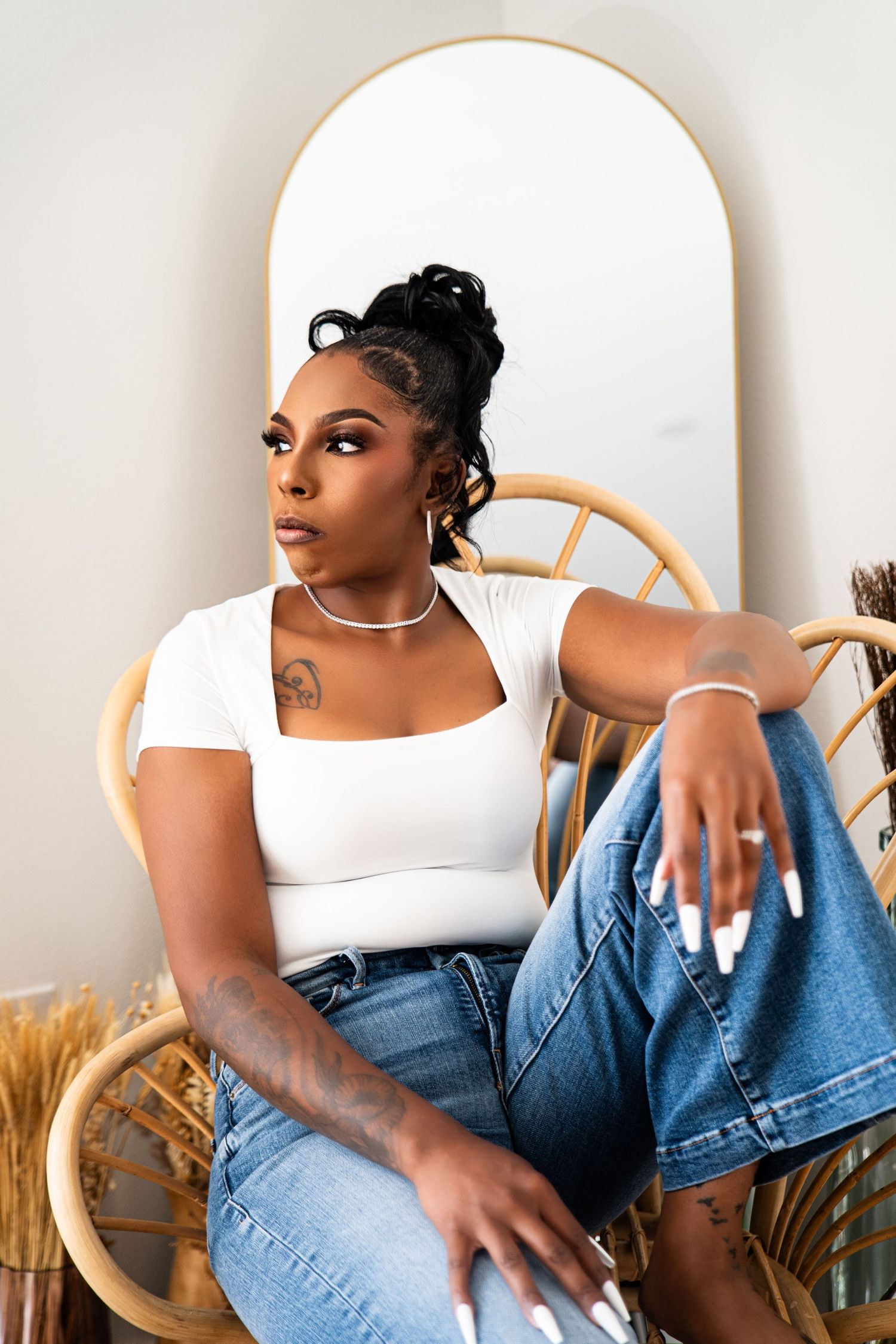Casual portrait session with denim and white top against neutral backdrop.