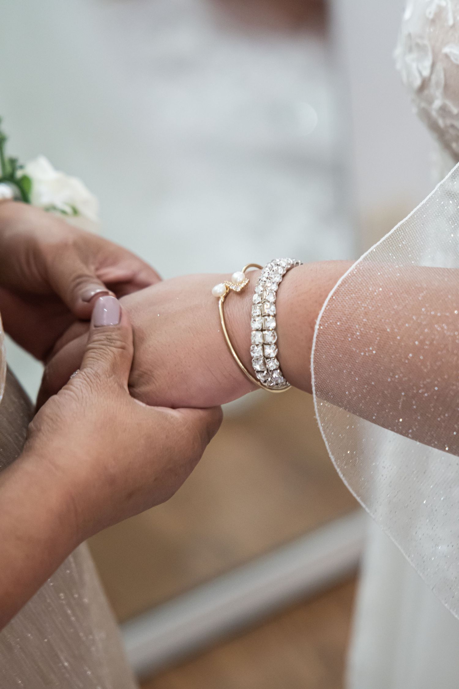 Close-up of delicate crystal bracelet being fastened on wrist.