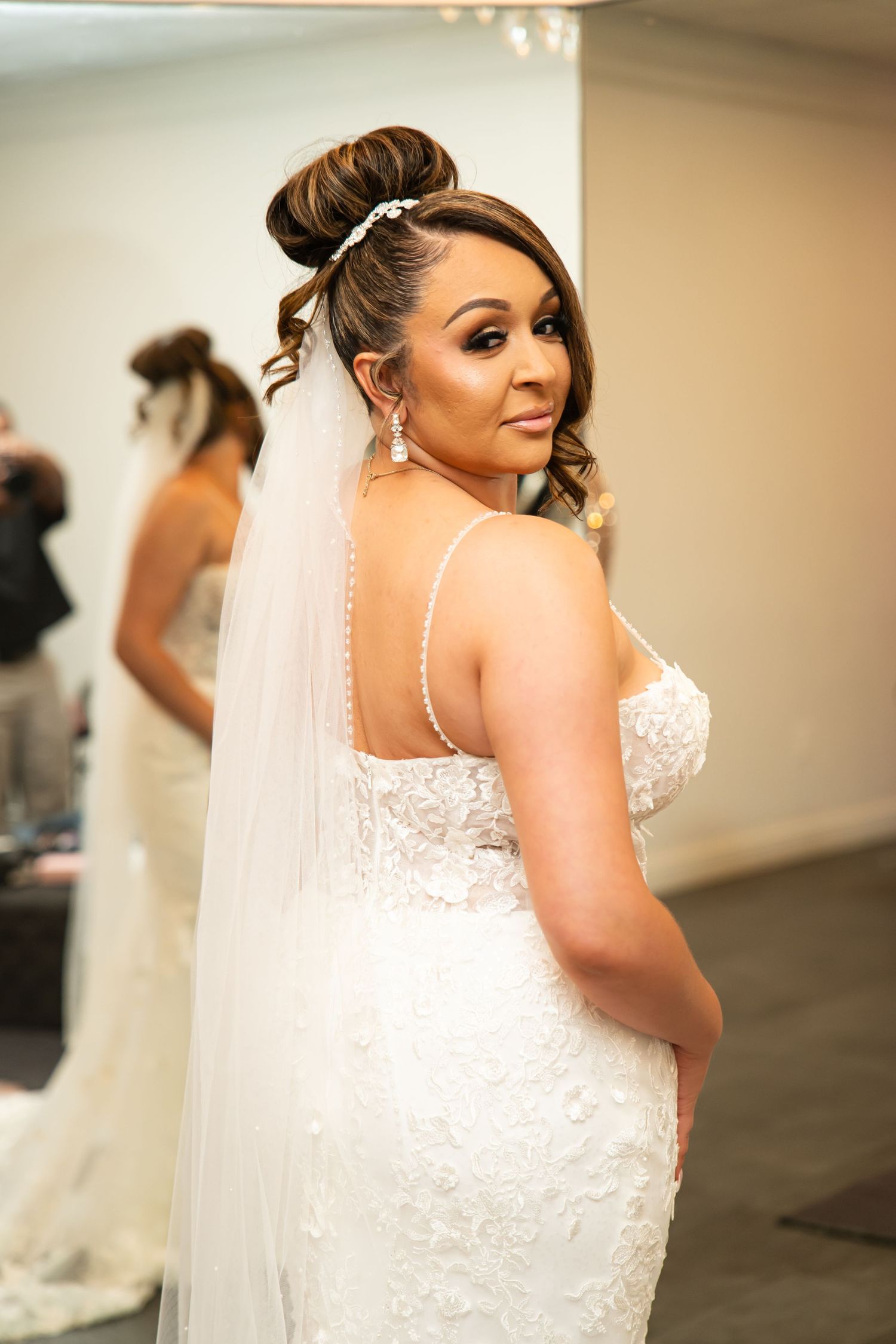 Bridal portrait showing intricate lace details of wedding dress and veil.