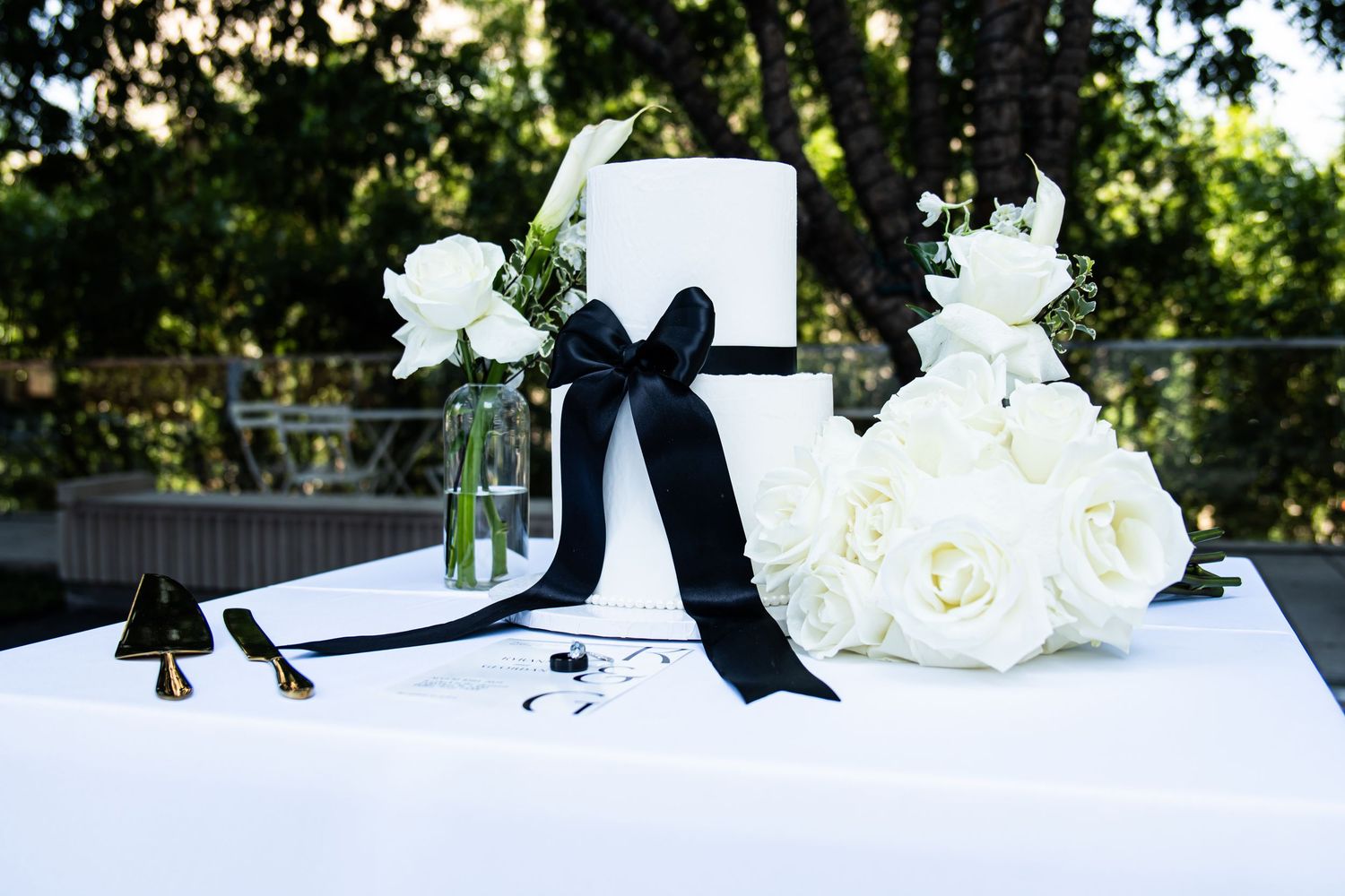 White roses and black ribbon create an elegant wedding decor arrangement.