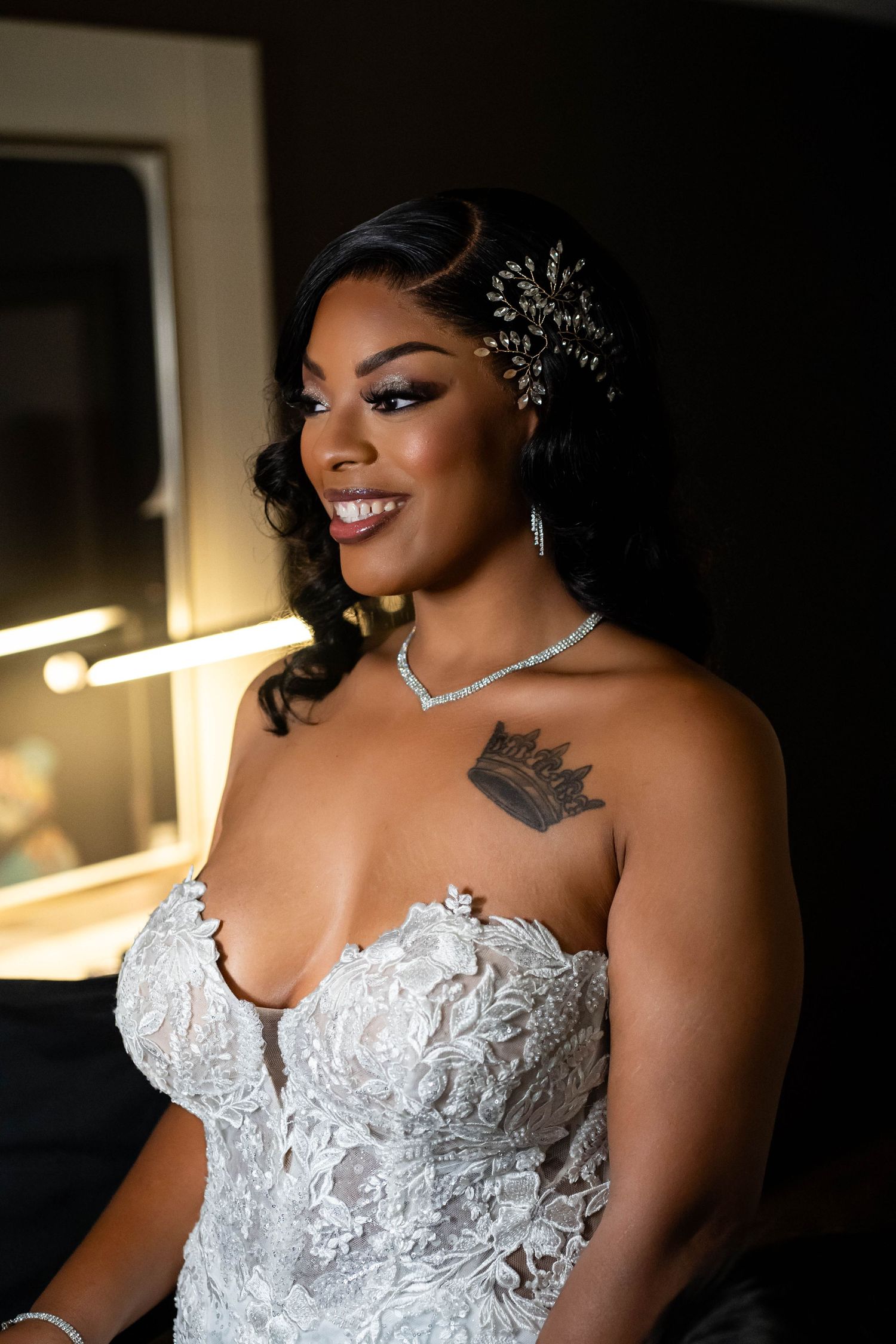 Elegant bridal portrait featuring lace dress, crystal hair accessory and delicate necklace.