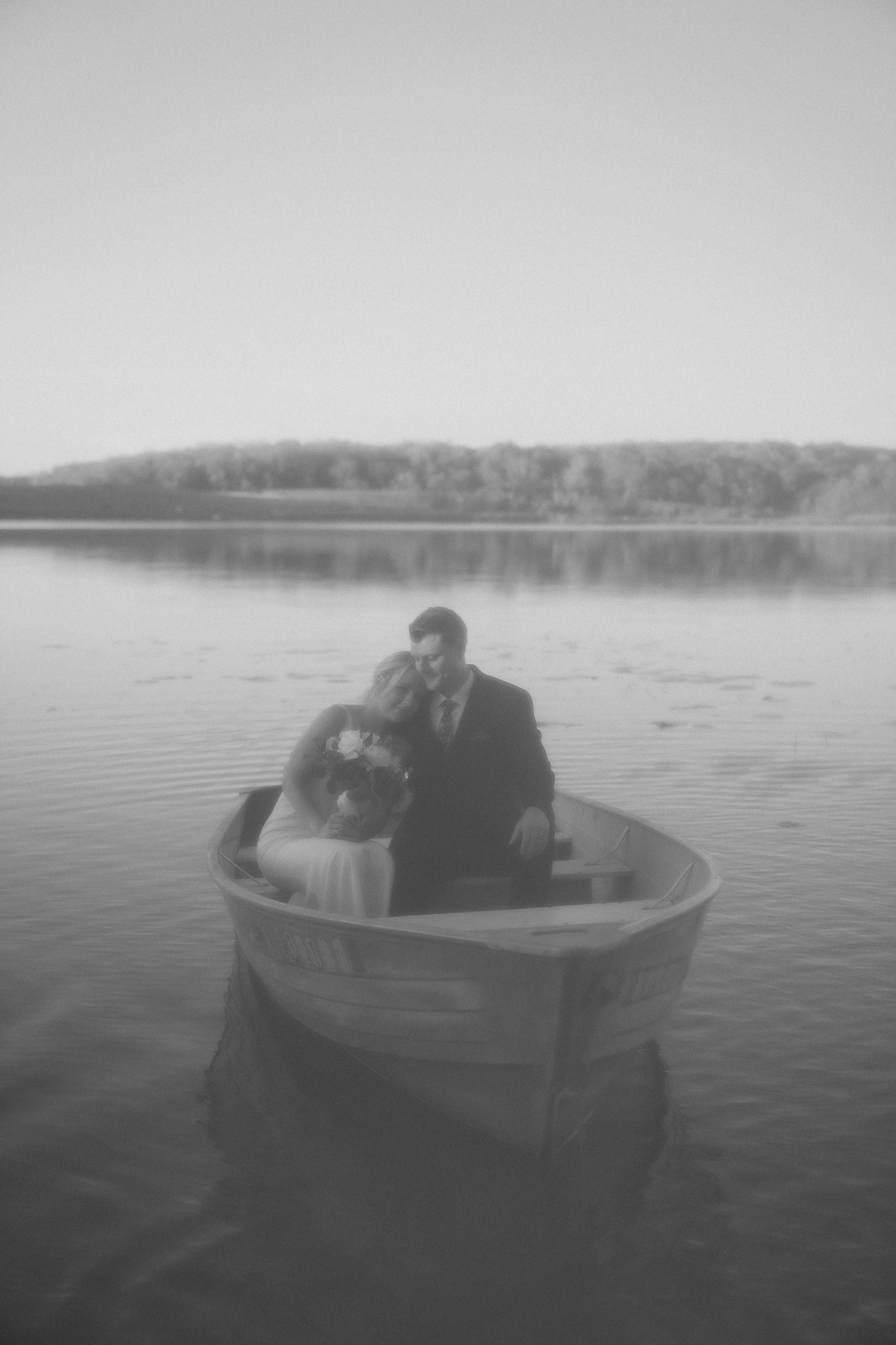 A series of black and white photos showing a small boat drifting on a misty lake with silhouettes visible inside.
