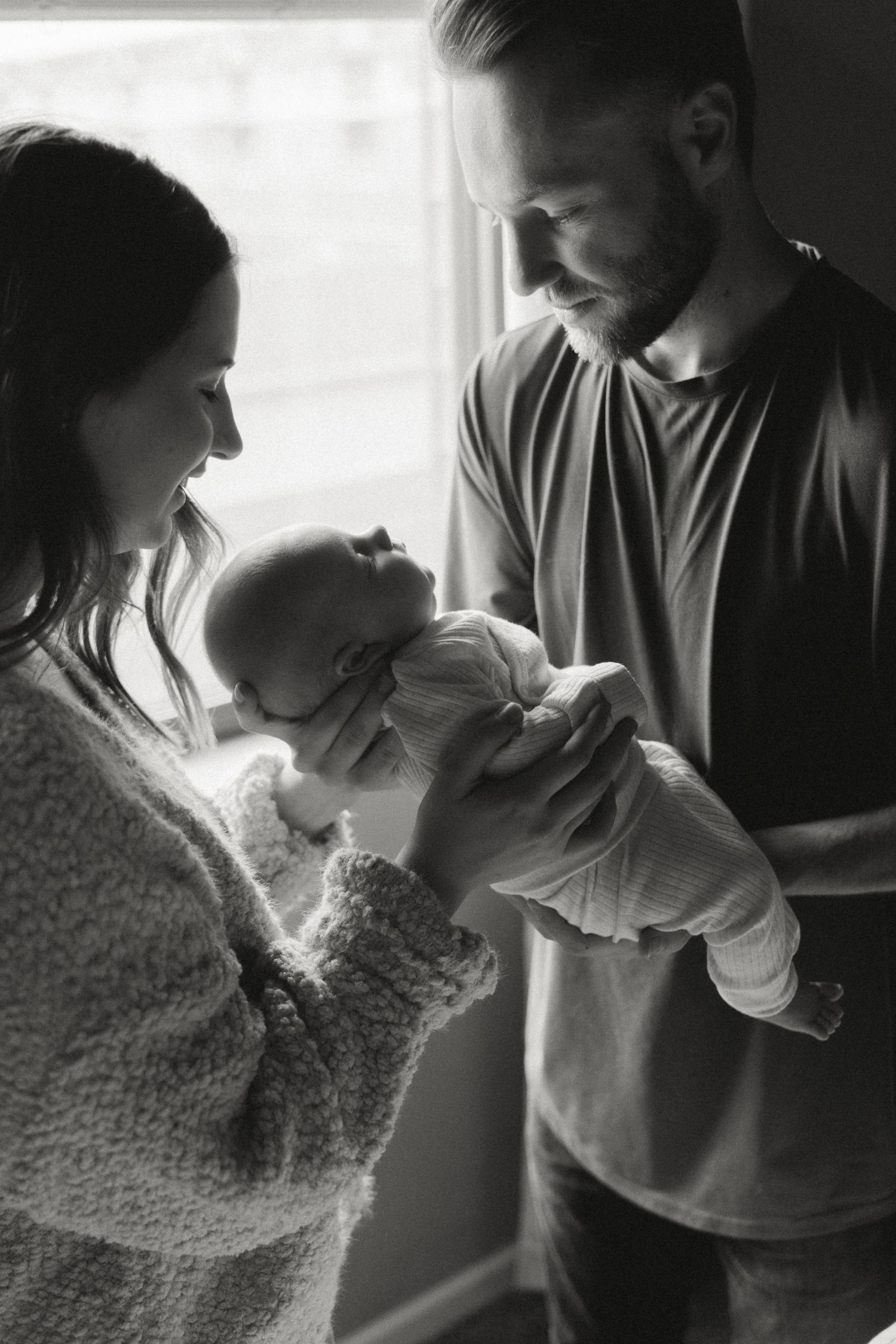 Tender family moment captured in soft black and white photography.