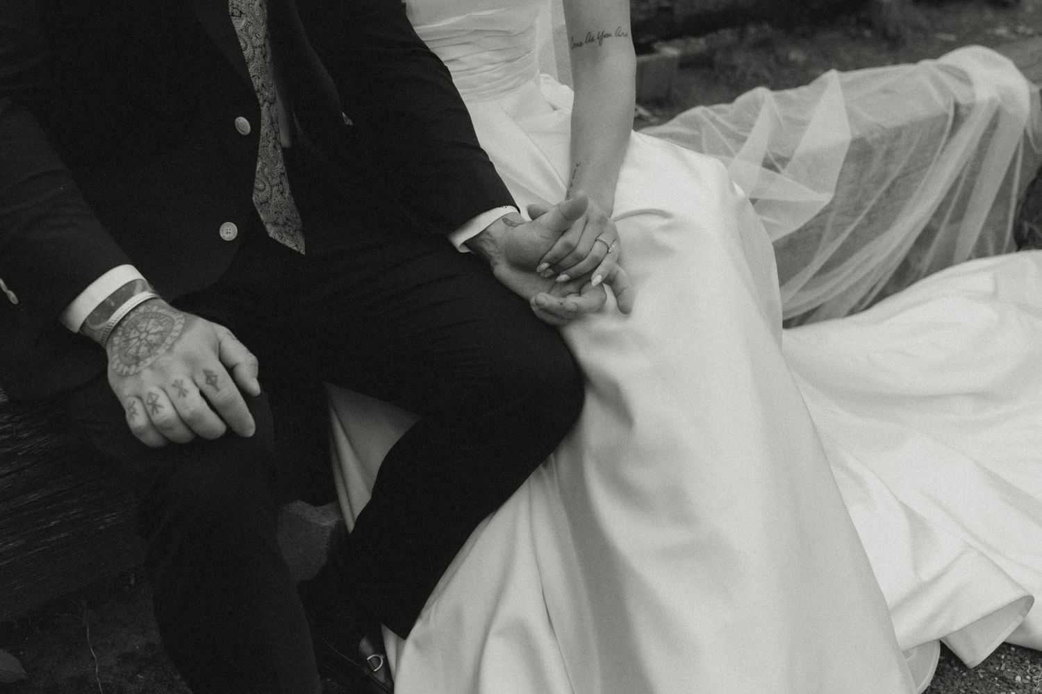 A close-up black and white photo of a couple's hands during their wedding ceremony.