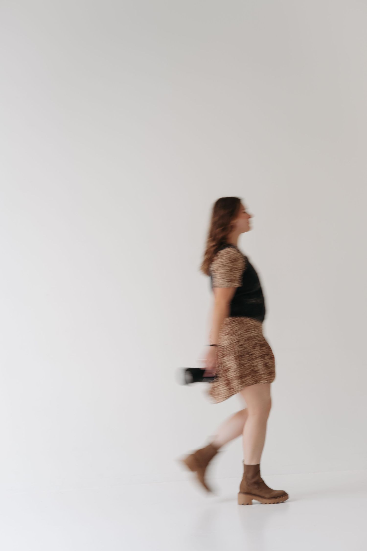 Dynamic motion shots of photographer twirling in leopard print dress against white background.