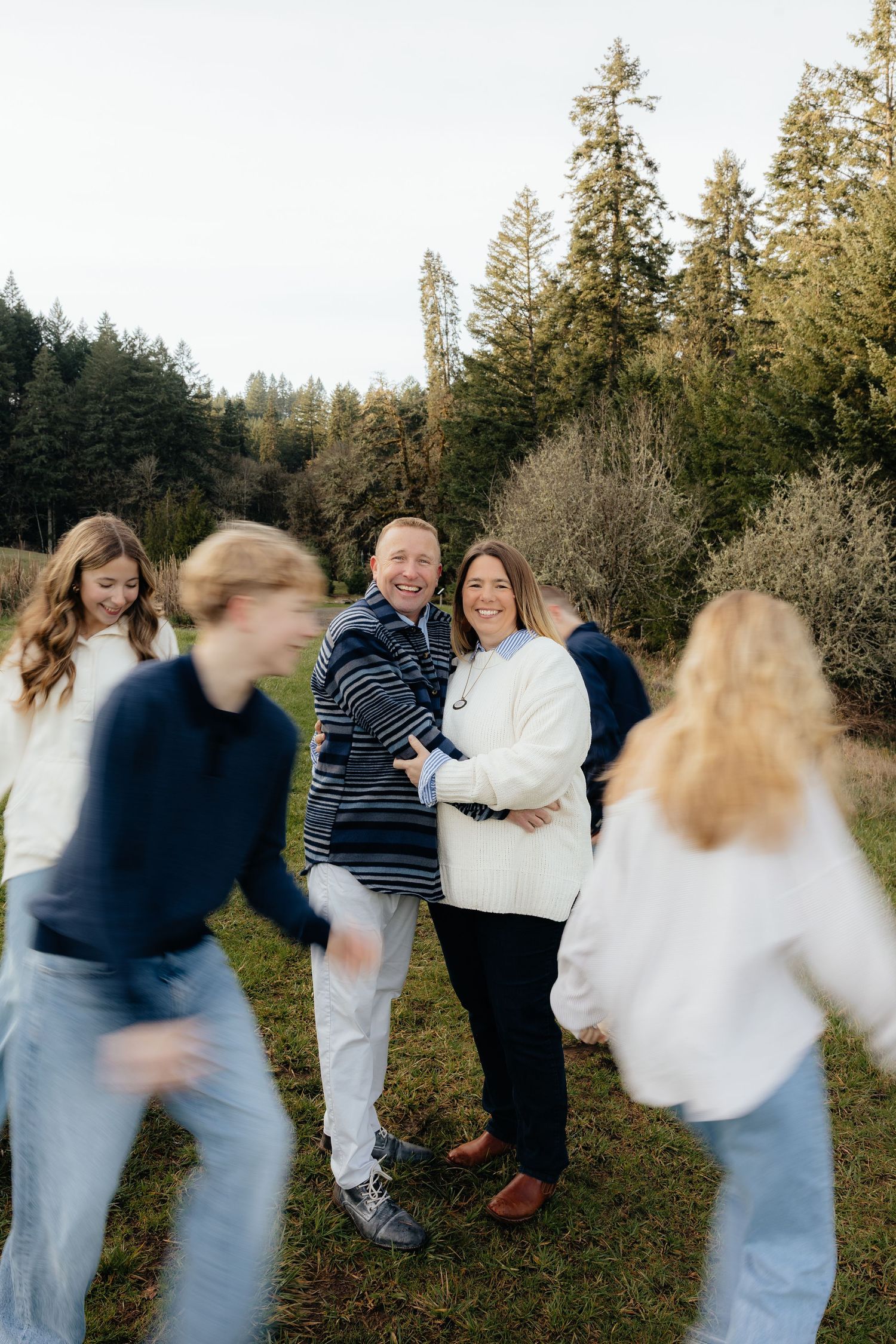 A sequence of motion blur photos showing people in casual attire playing and moving around in a wooded outdoor setting.