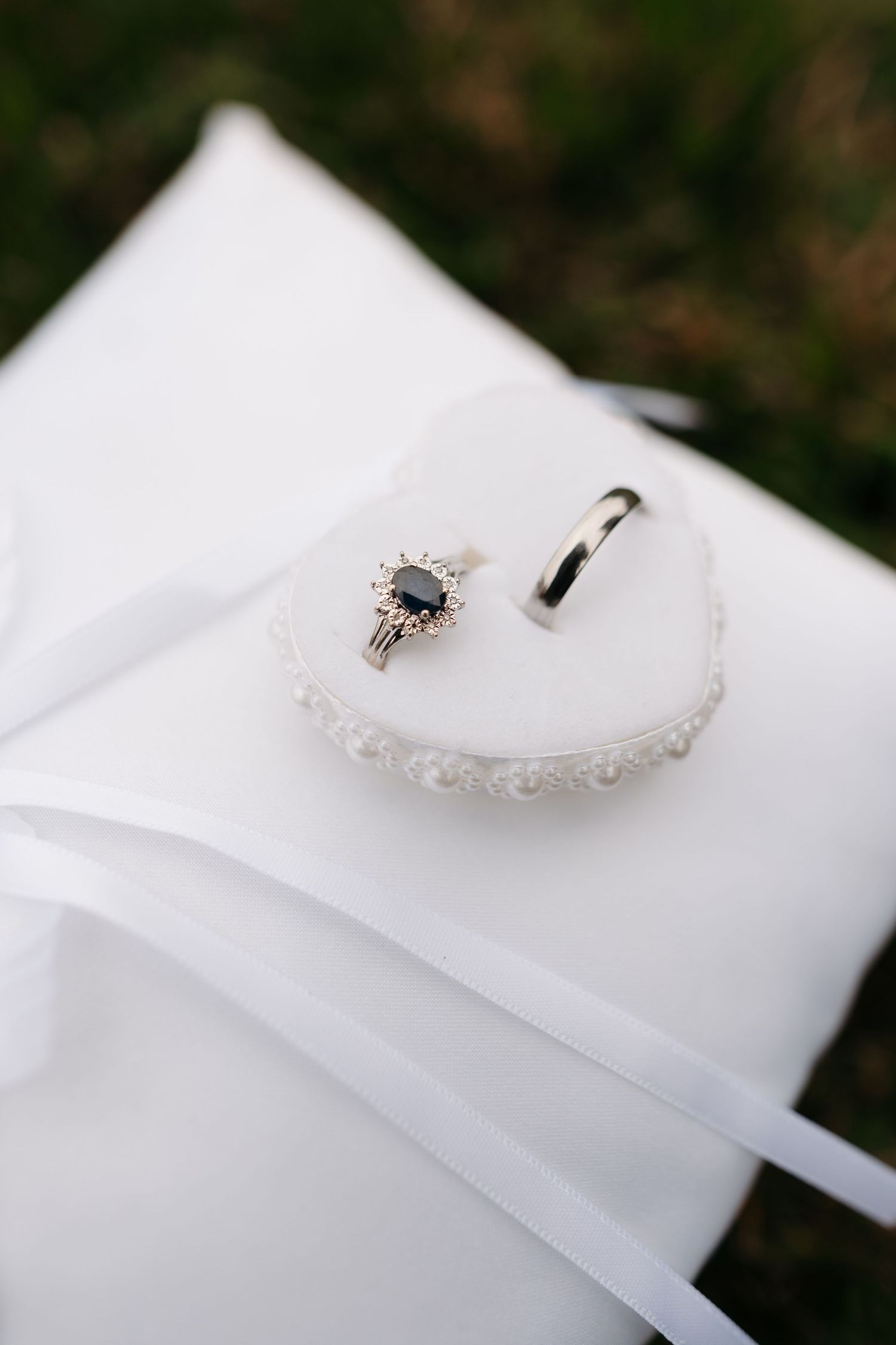 Elegant diamond engagement ring on white fabric with soft focus.