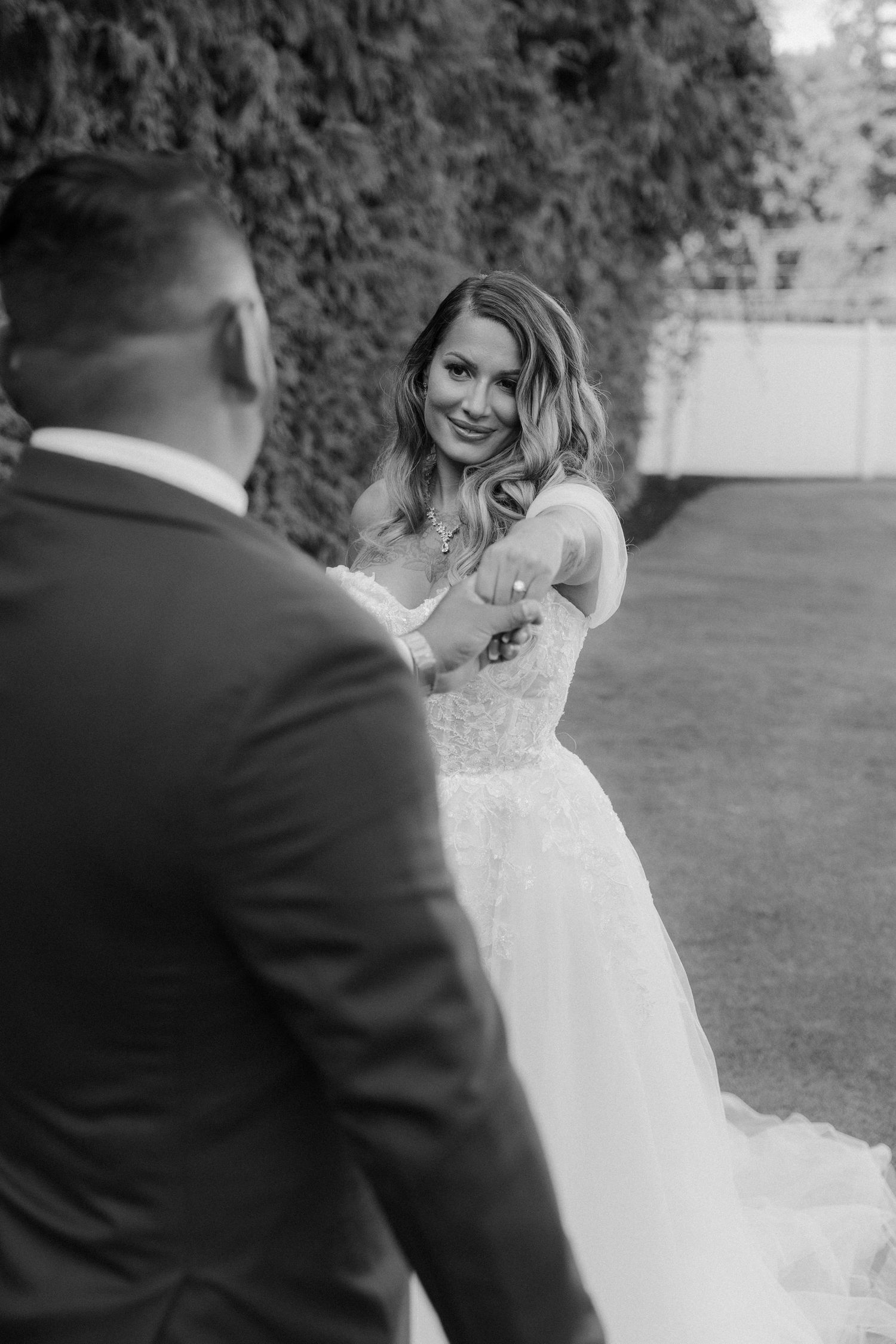 A sequence of romantic black and white wedding photos showing a bride in a lace dress twirling playfully outdoors.