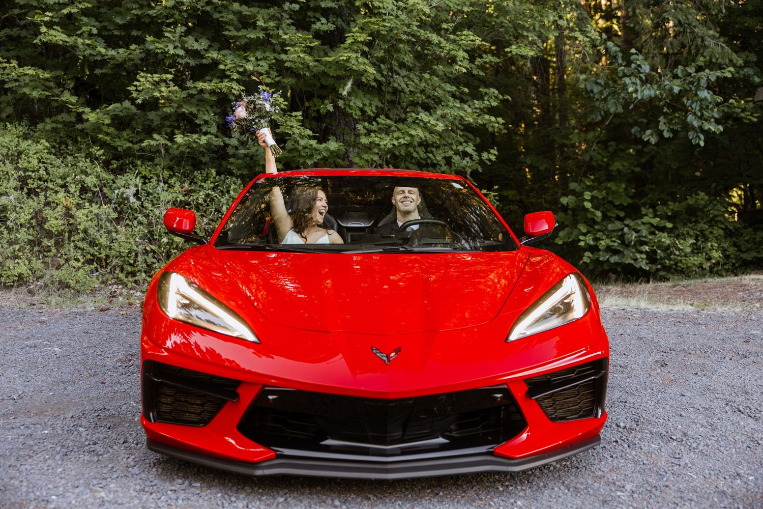 A bright red Chevrolet Corvette C8 shown from multiple angles parked on a gravel road in a wooded setting.