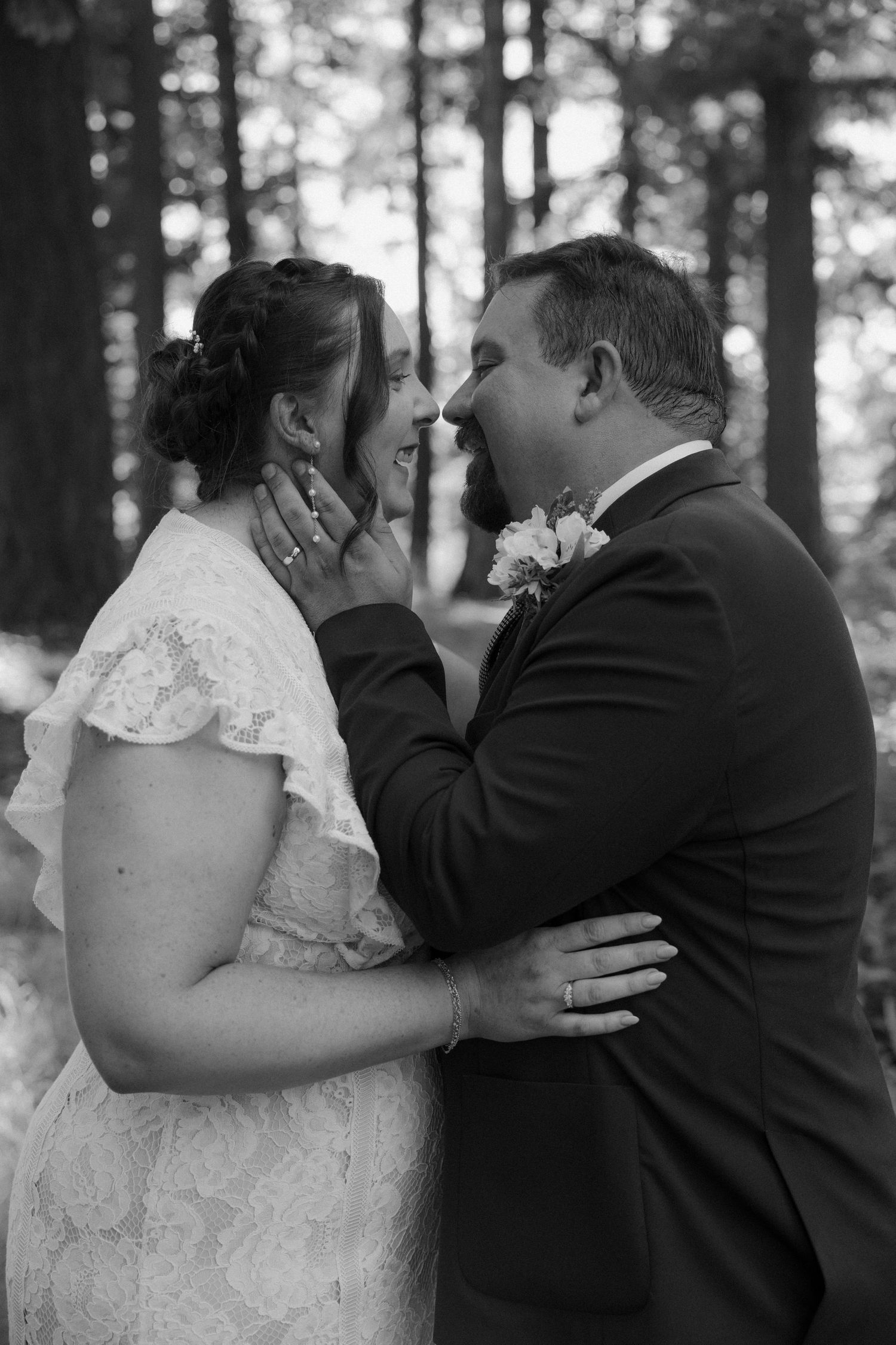 Black and white wedding photography sequence showing romantic first kiss moments between newlyweds in a forest setting.