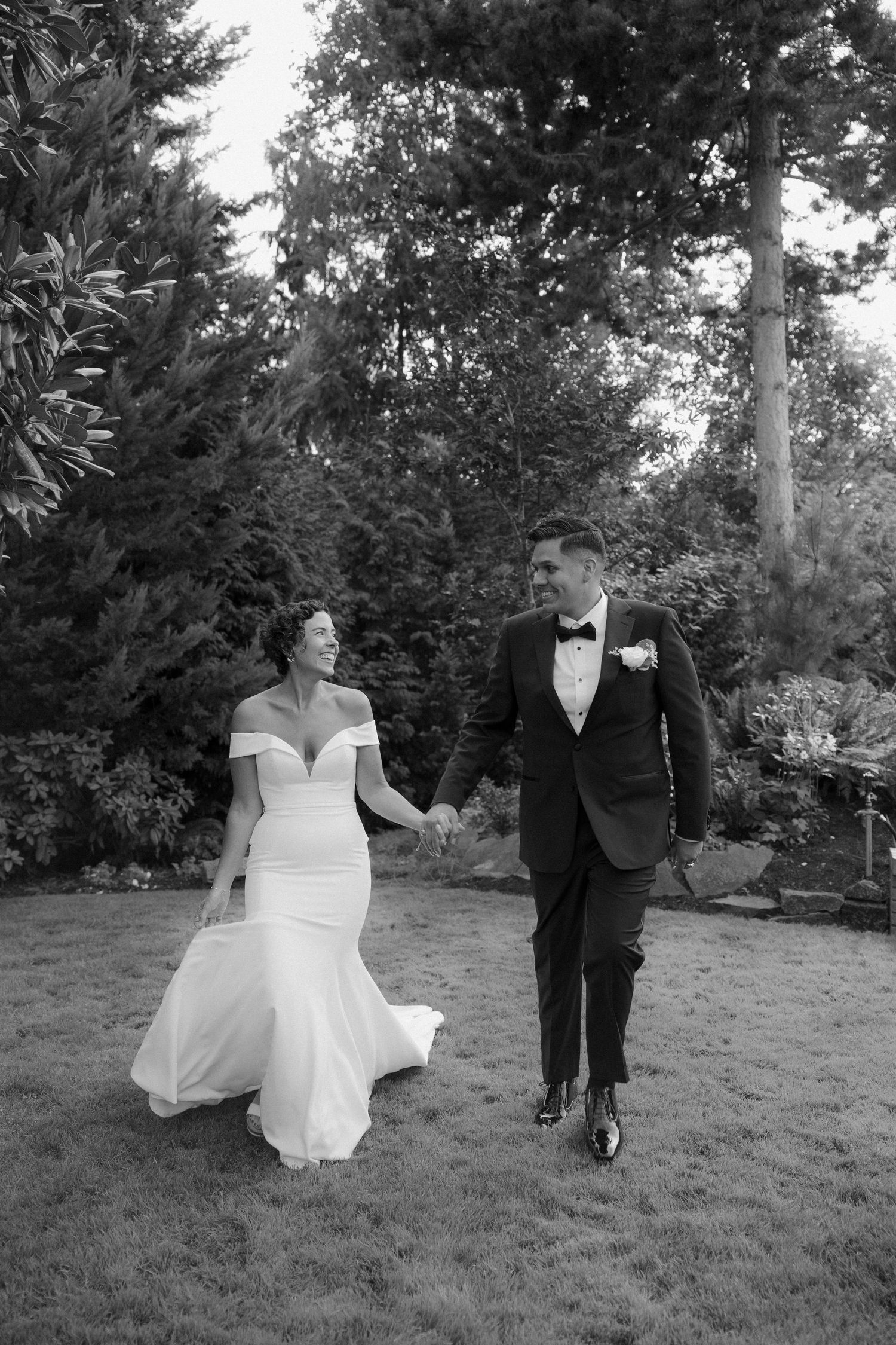 Black and white photos of a couple walking through a garden setting during their wedding day.