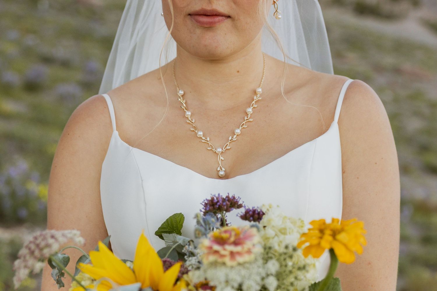 A wedding party holds vibrant yellow sunflower bouquets against a natural outdoor backdrop.