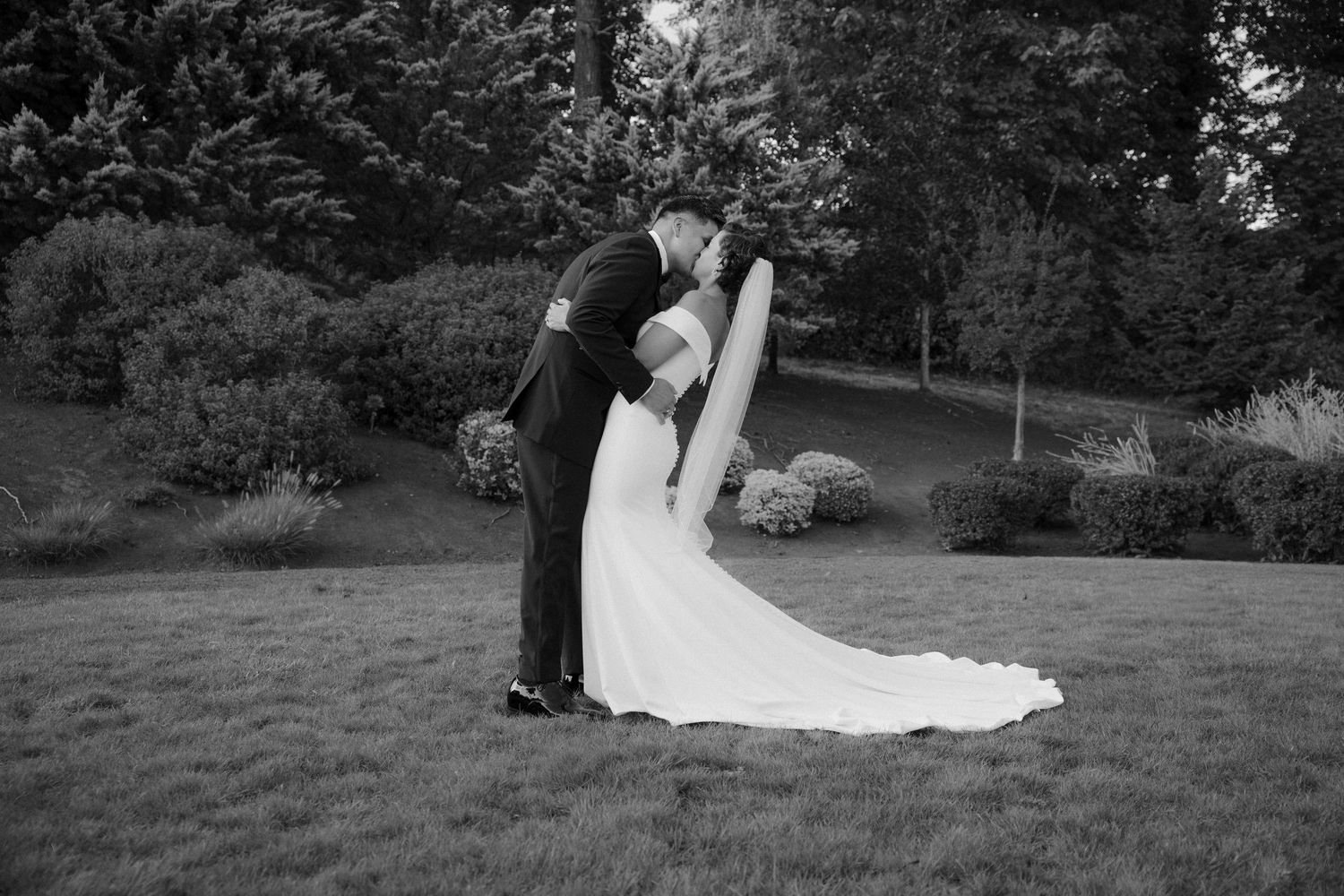 Romantic black and white wedding photo series showing intimate moments between newlyweds in an outdoor garden setting.