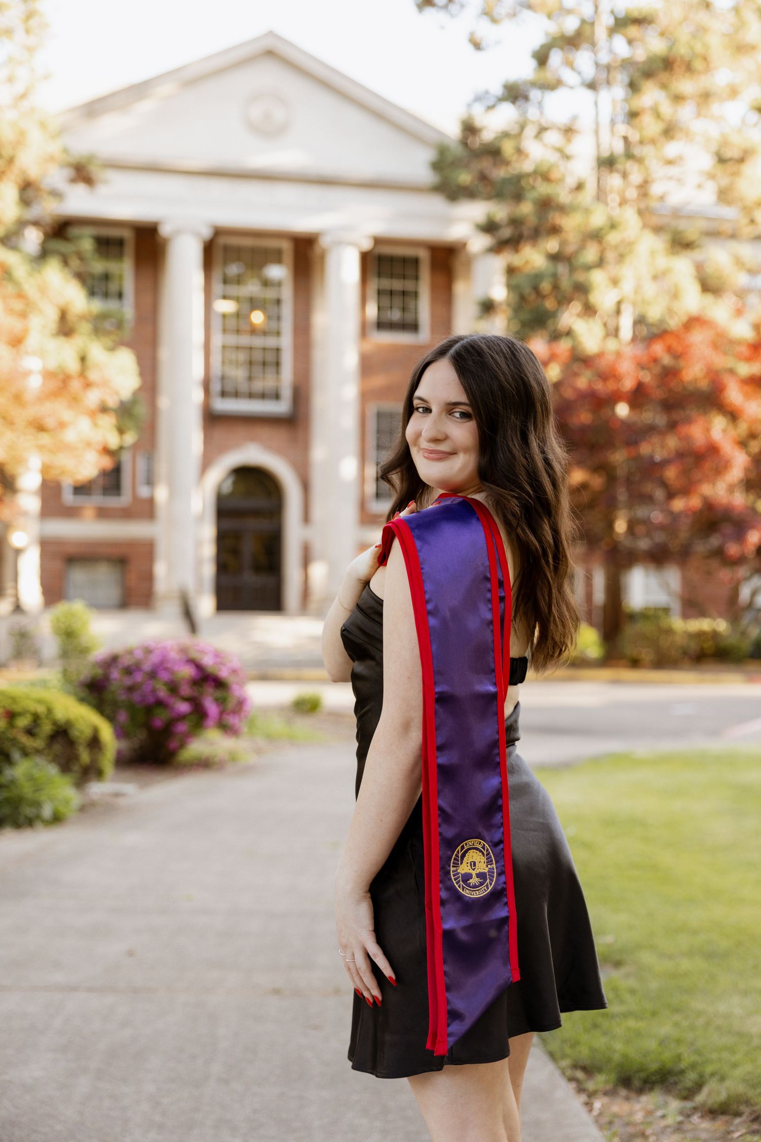 Graduation photos on a college campus with brick buildings and blooming azaleas in spring.