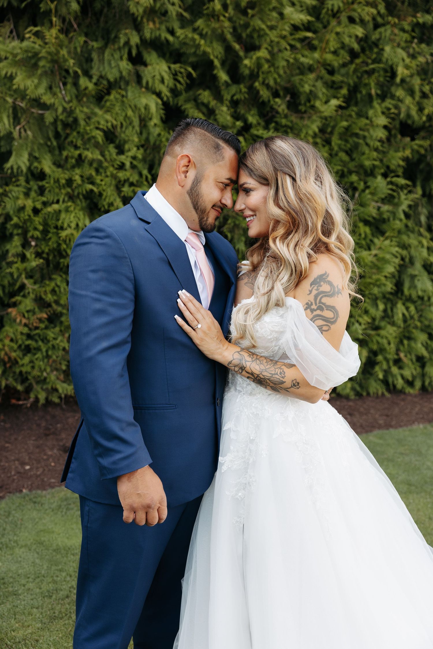 Romantic outdoor wedding portraits with couple in white dress and navy suit.