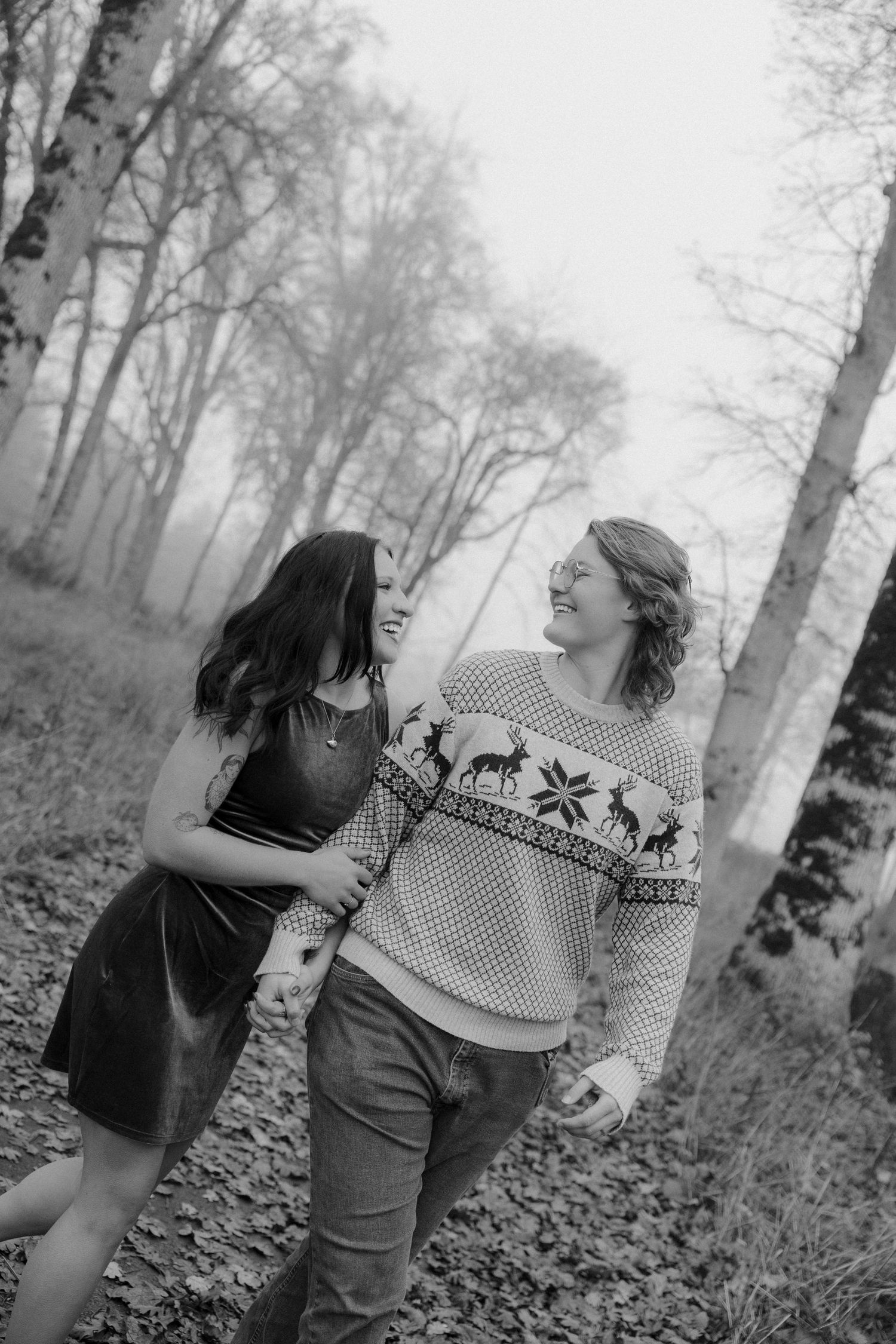Black and white photos of couple walking and laughing together in wooded setting.