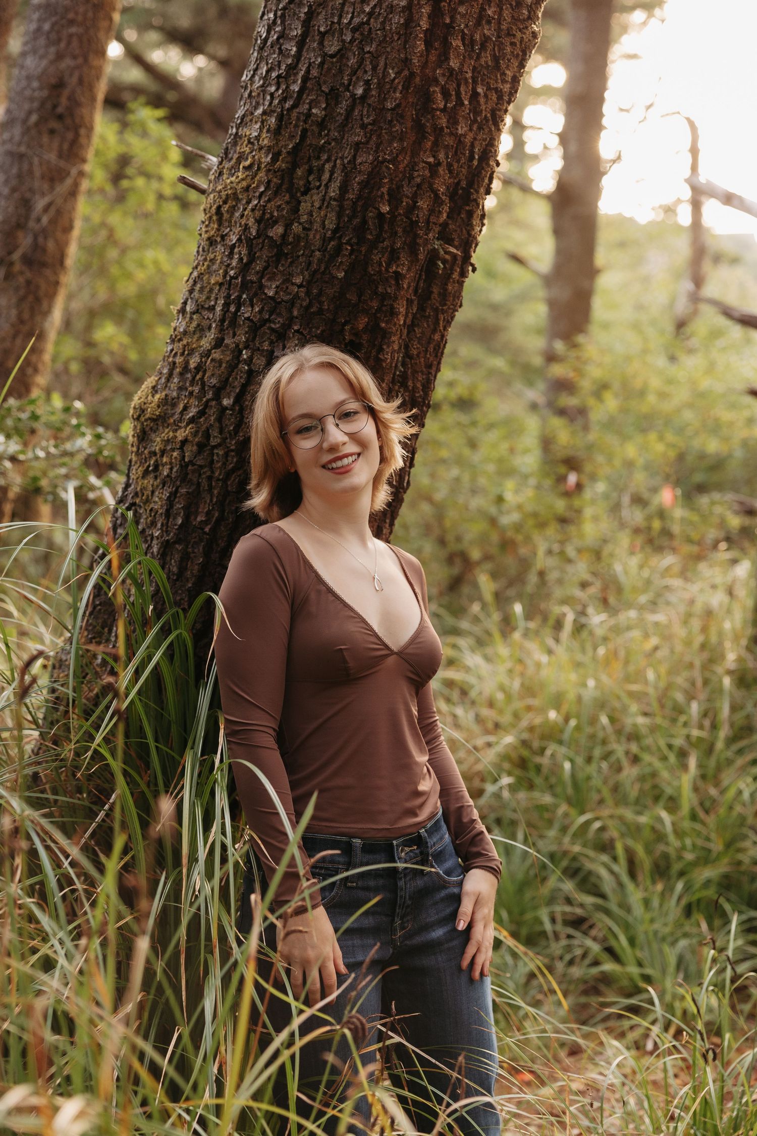 Three connected photos show someone in a brown top and jeans posing casually against a tree trunk in a sunlit forest setting.