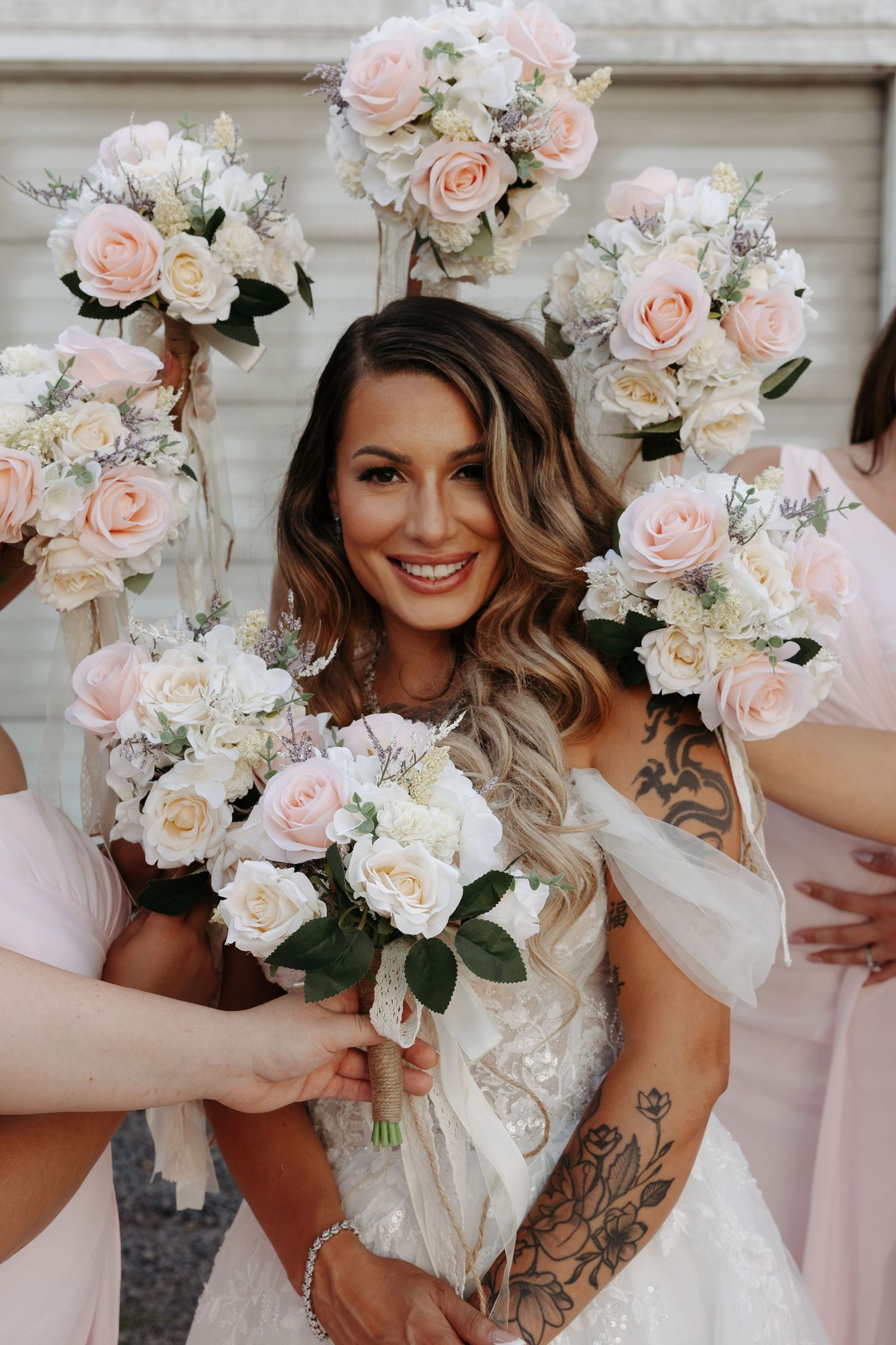 Wedding bouquet details featuring soft pink and white roses with greenery.