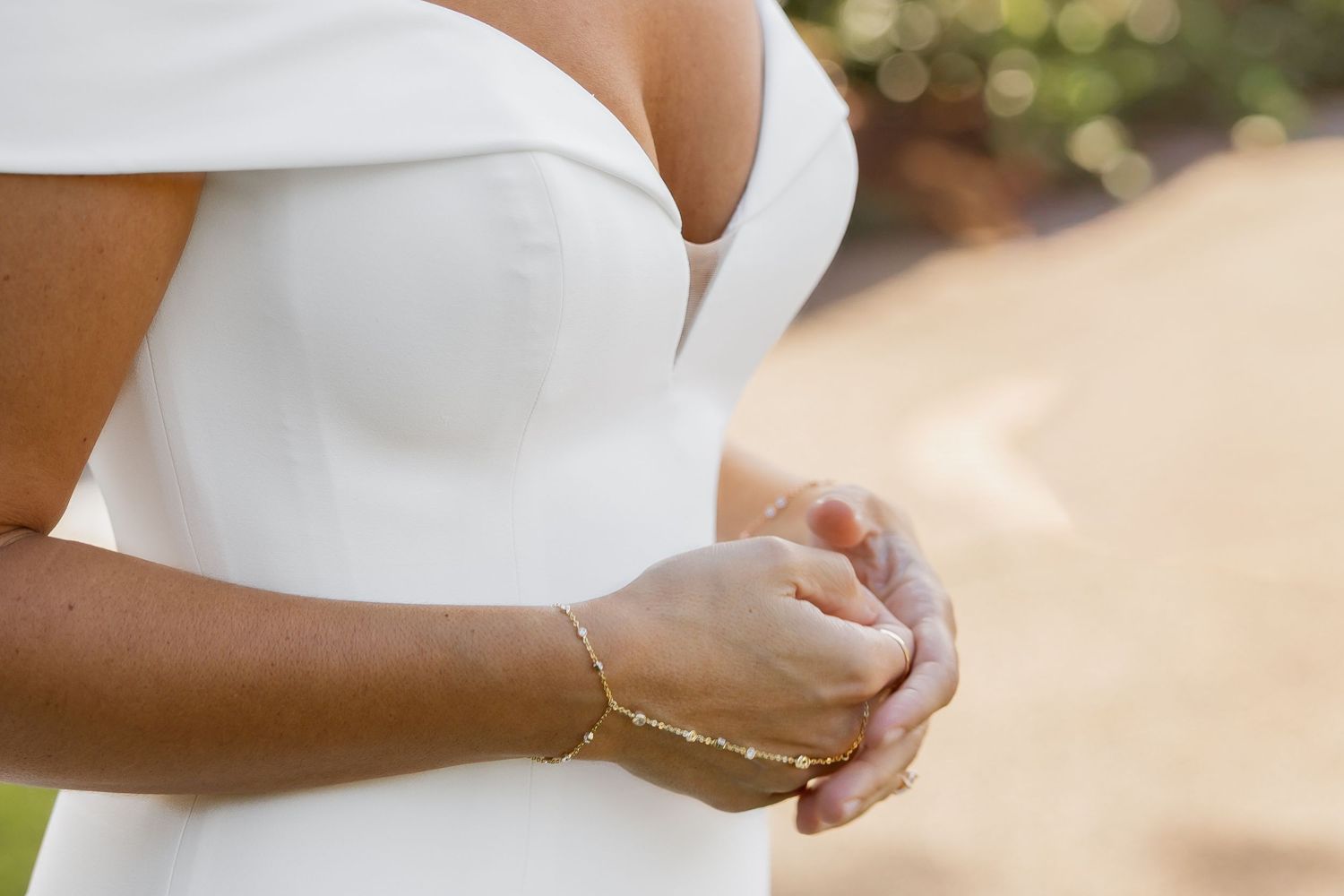 Close-up view of a white wedding dress detail with soft natural lighting and blurred background.