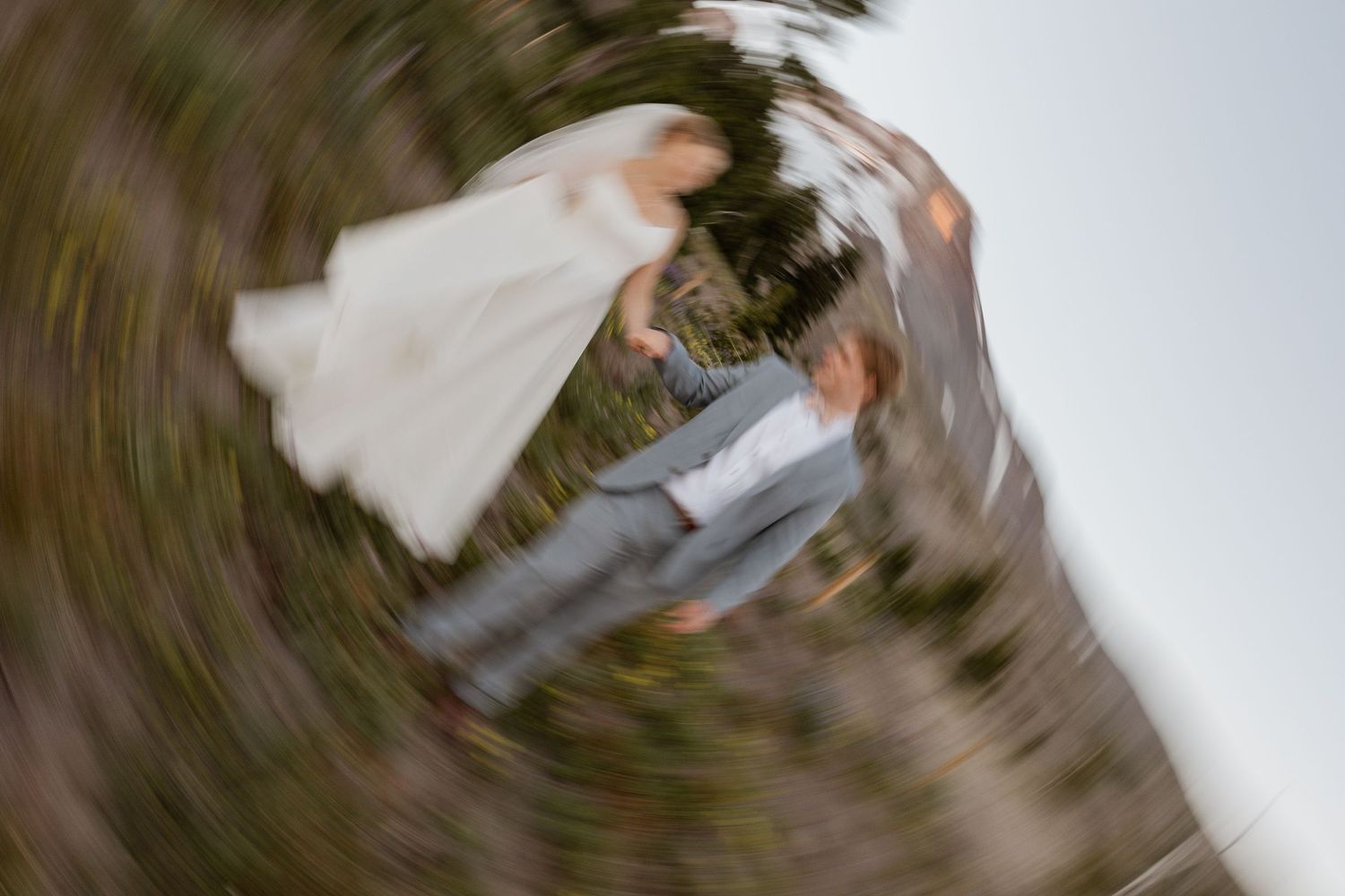 A sequence of blurred motion photos showing a couple dancing in wedding attire against a dark background.