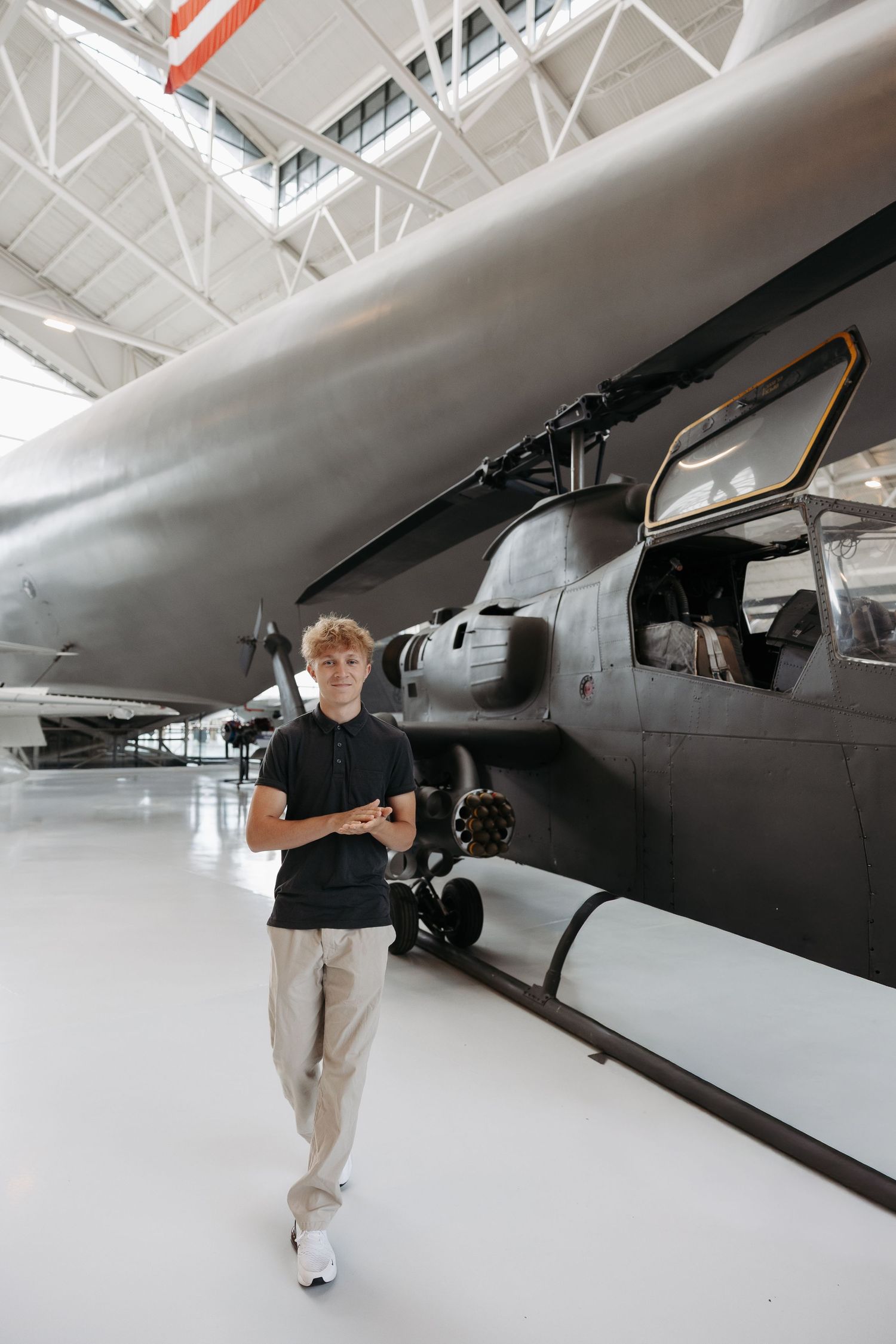 A vintage military aircraft on display in a bright museum hangar with white floors and ceiling.