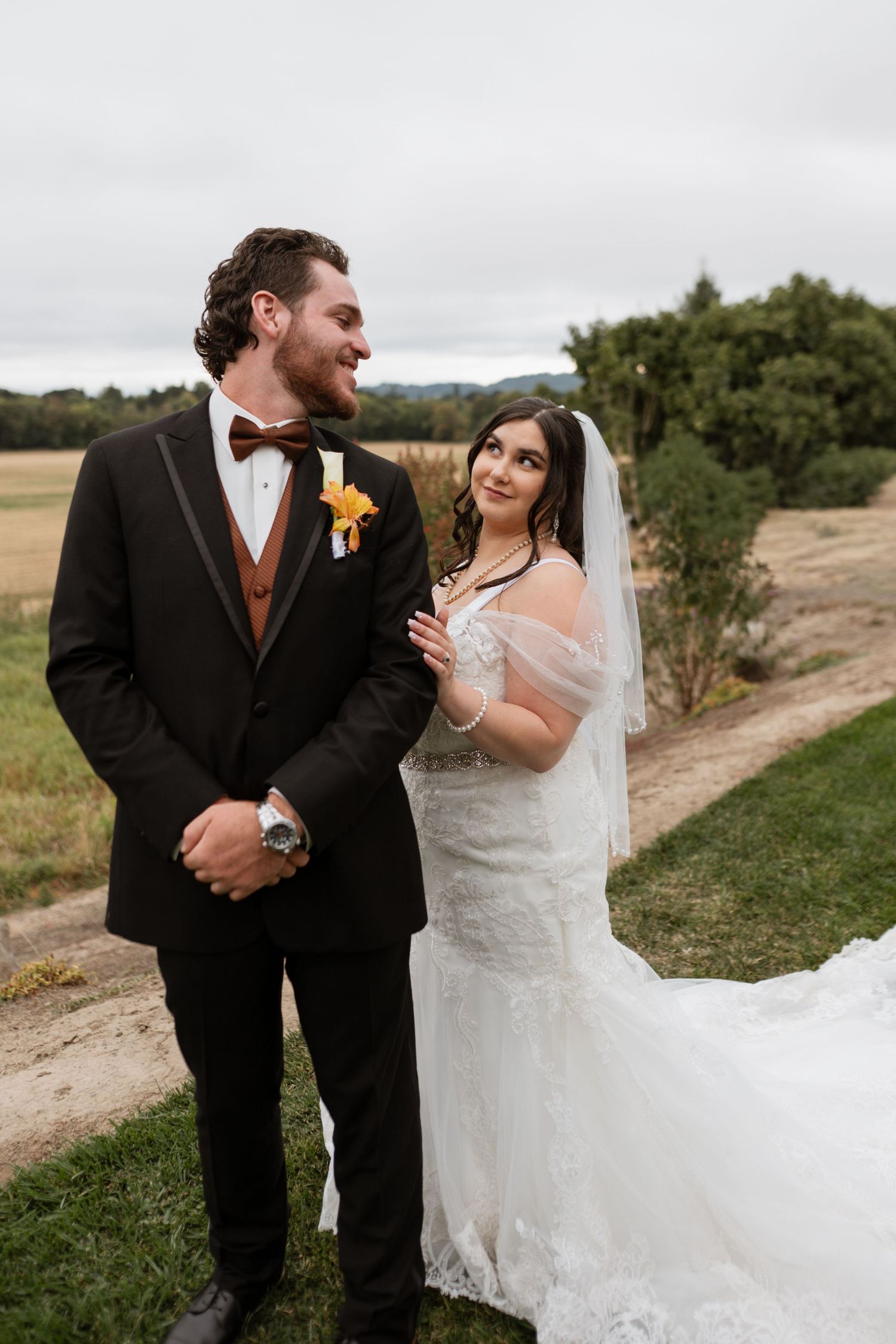 Wedding couple sharing laughter together on a rustic outdoor path.