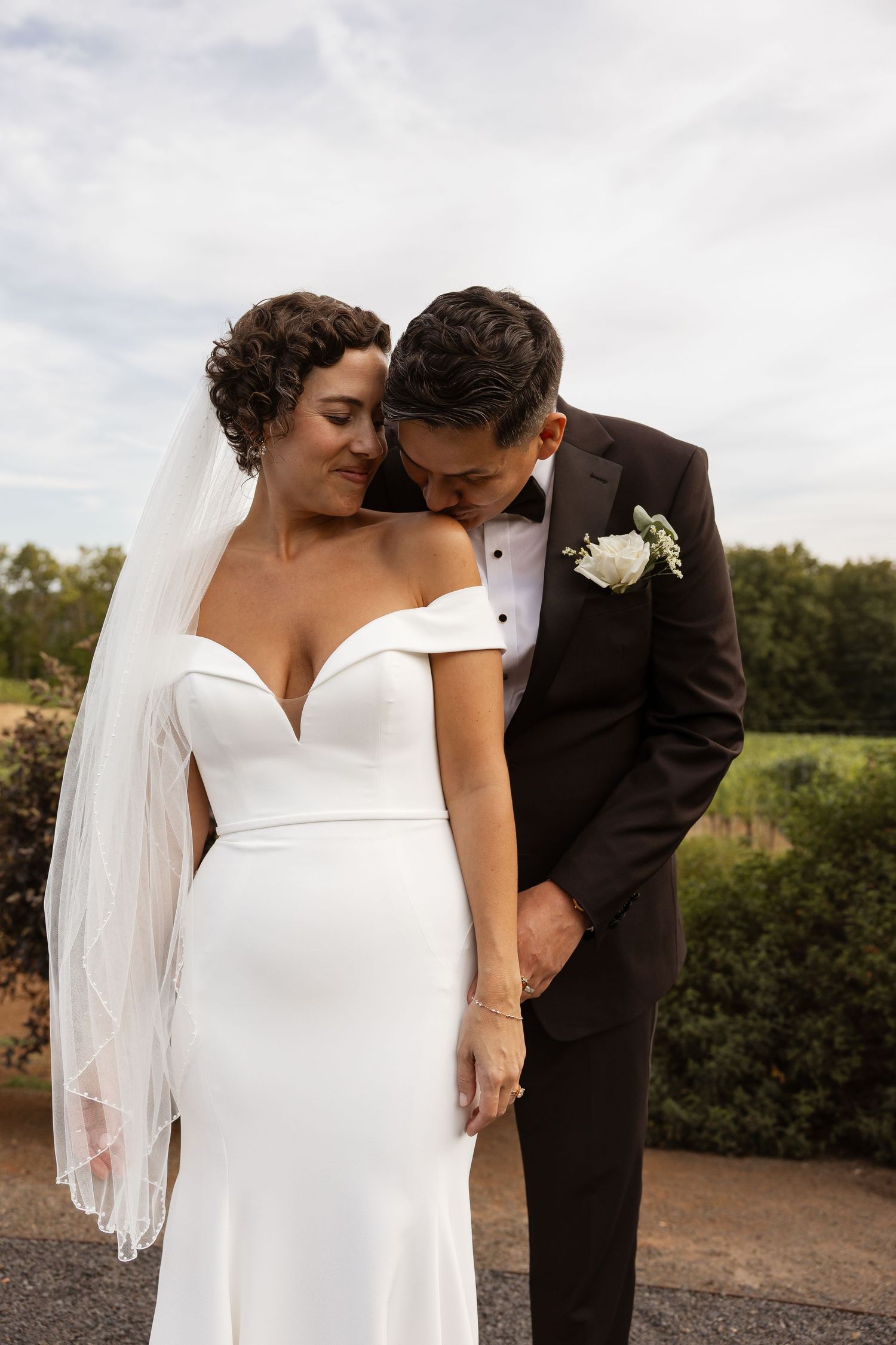Intimate wedding portraits captured against a natural landscape backdrop.