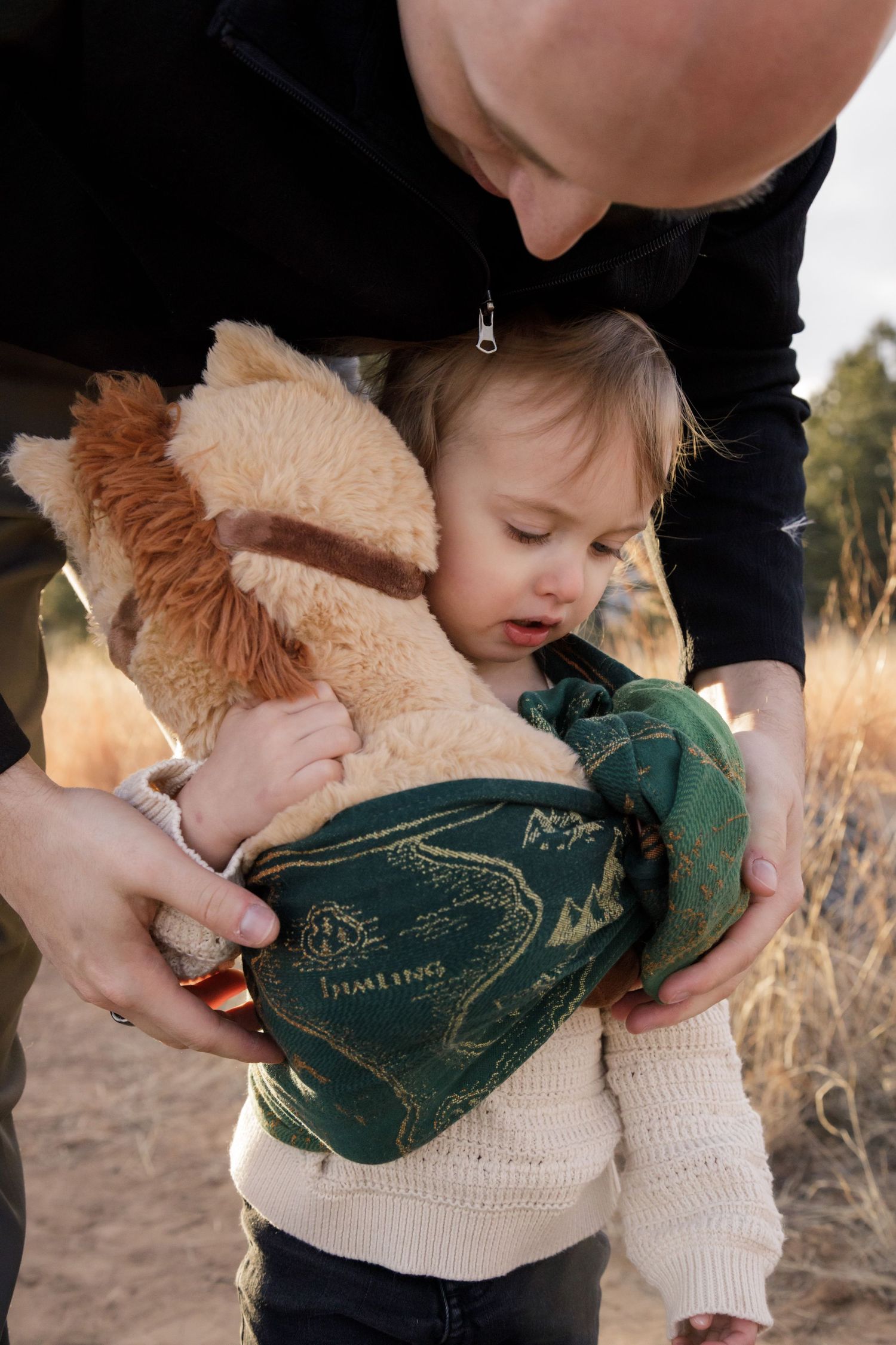 A series of tender moments between a child in a cream sweater and a stuffed lion toy against a natural outdoor backdrop.