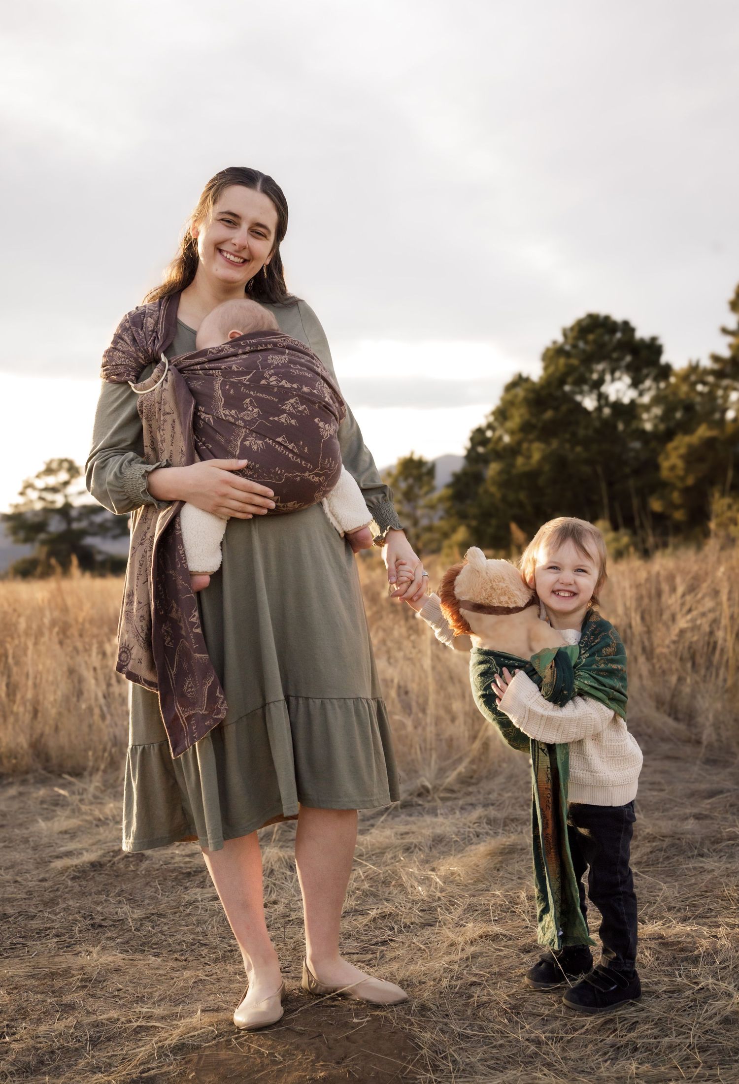 A parent and small child share playful moments together in a rustic outdoor field setting at golden hour.