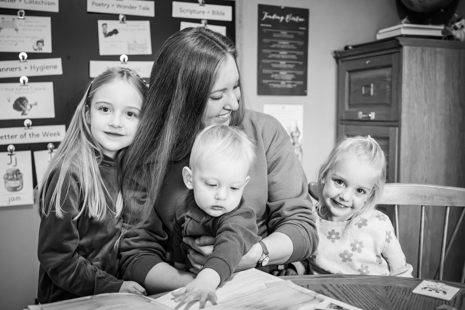 A black and white photo showing a family reading together at a table.