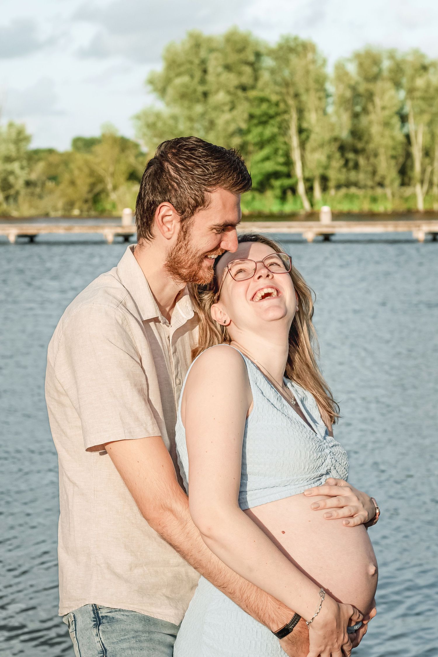 Zwanger stel die samen lachen tijdens een zwangerschapsshoot in Zuid-Holland.