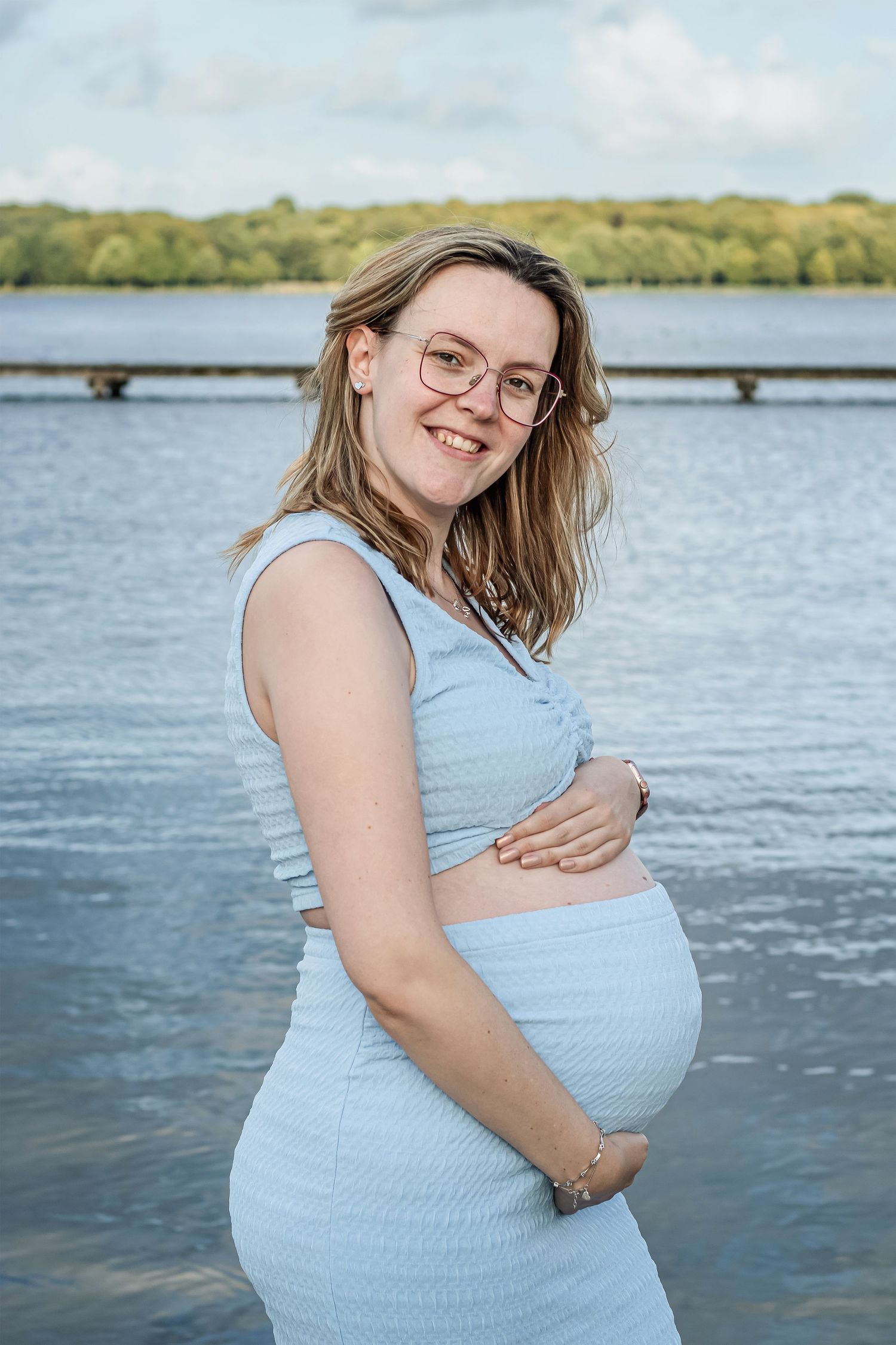 Zwangere mama die vol liefde haar buik vast houdt ijdens een zwangerschapsshoot in Zuid-Holland.