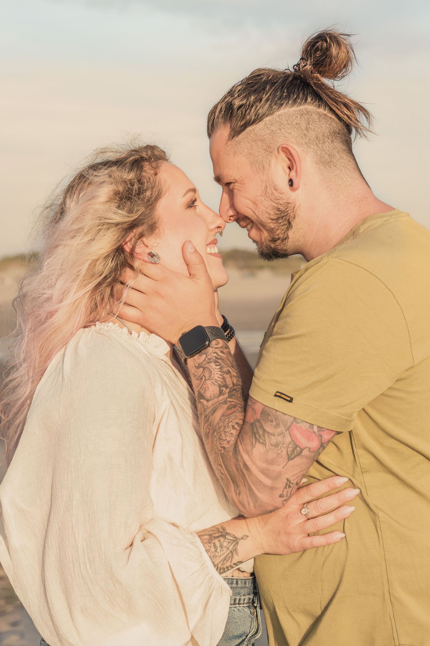 Koppel op het strand intiem met golden hour tijdens een lovesshoot in Zuid-Holland.