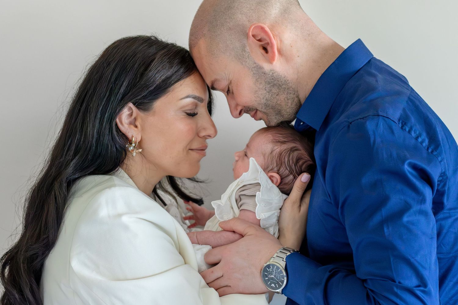 Papa en mama knuffelend met pasgeboren baby tijdens een newbornshoot in Zuid-Holland.