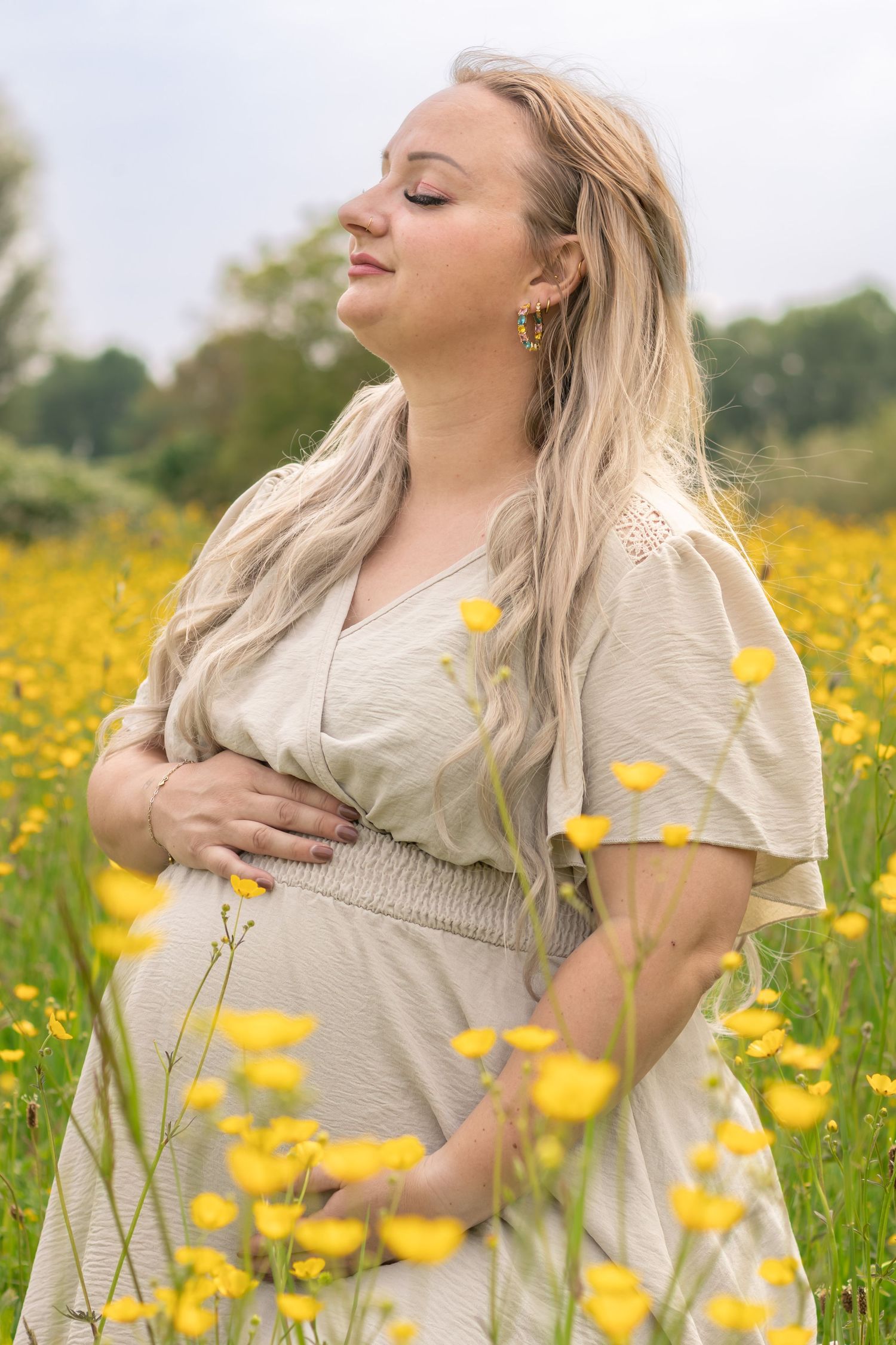 Zwangere vrouw in bloemenveld tijdens een zwangerschapshoot in Zuid-Holland.