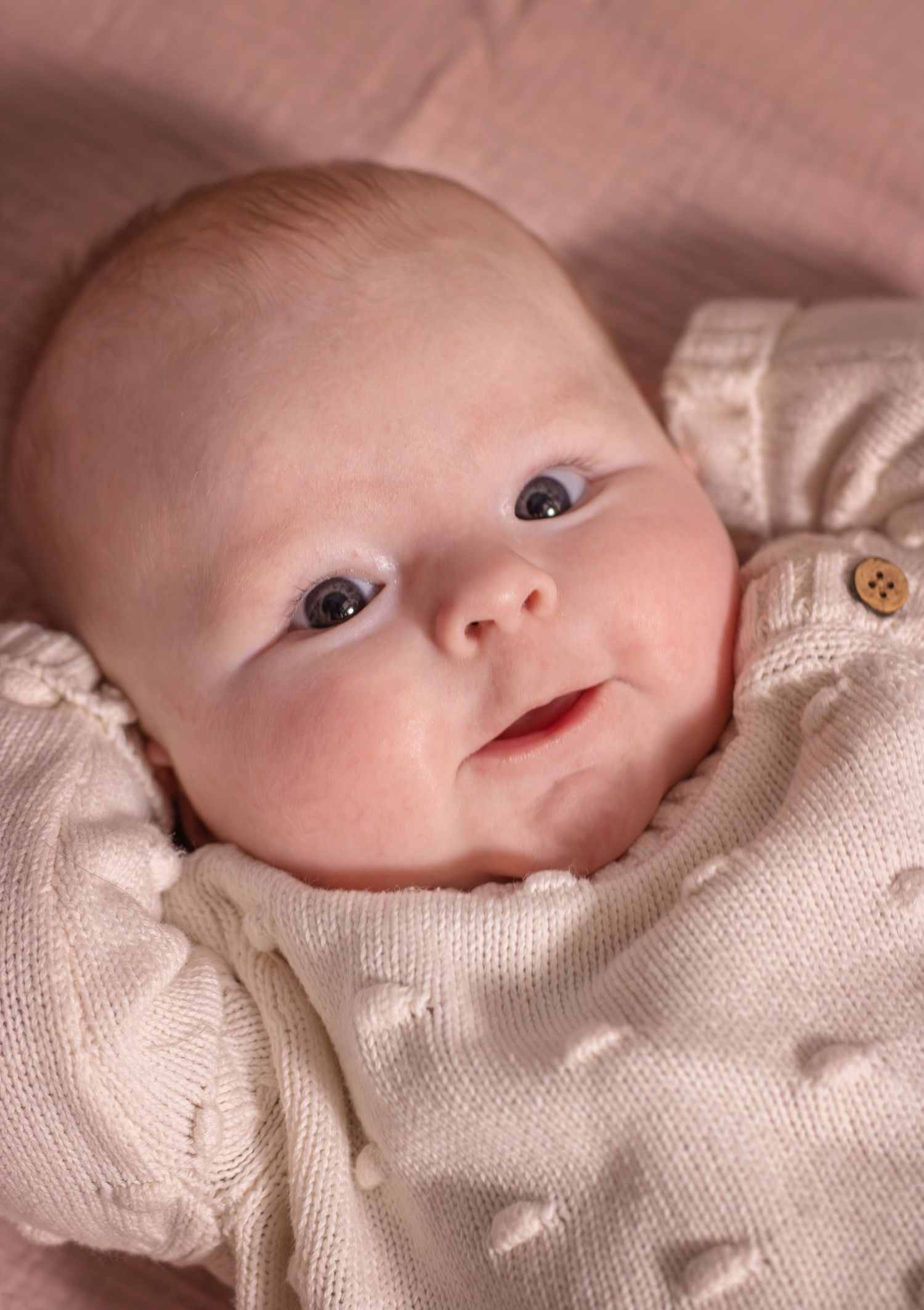 Pasgeboren baby lachend tijdens een newbornshoot in Zuid-Holland.