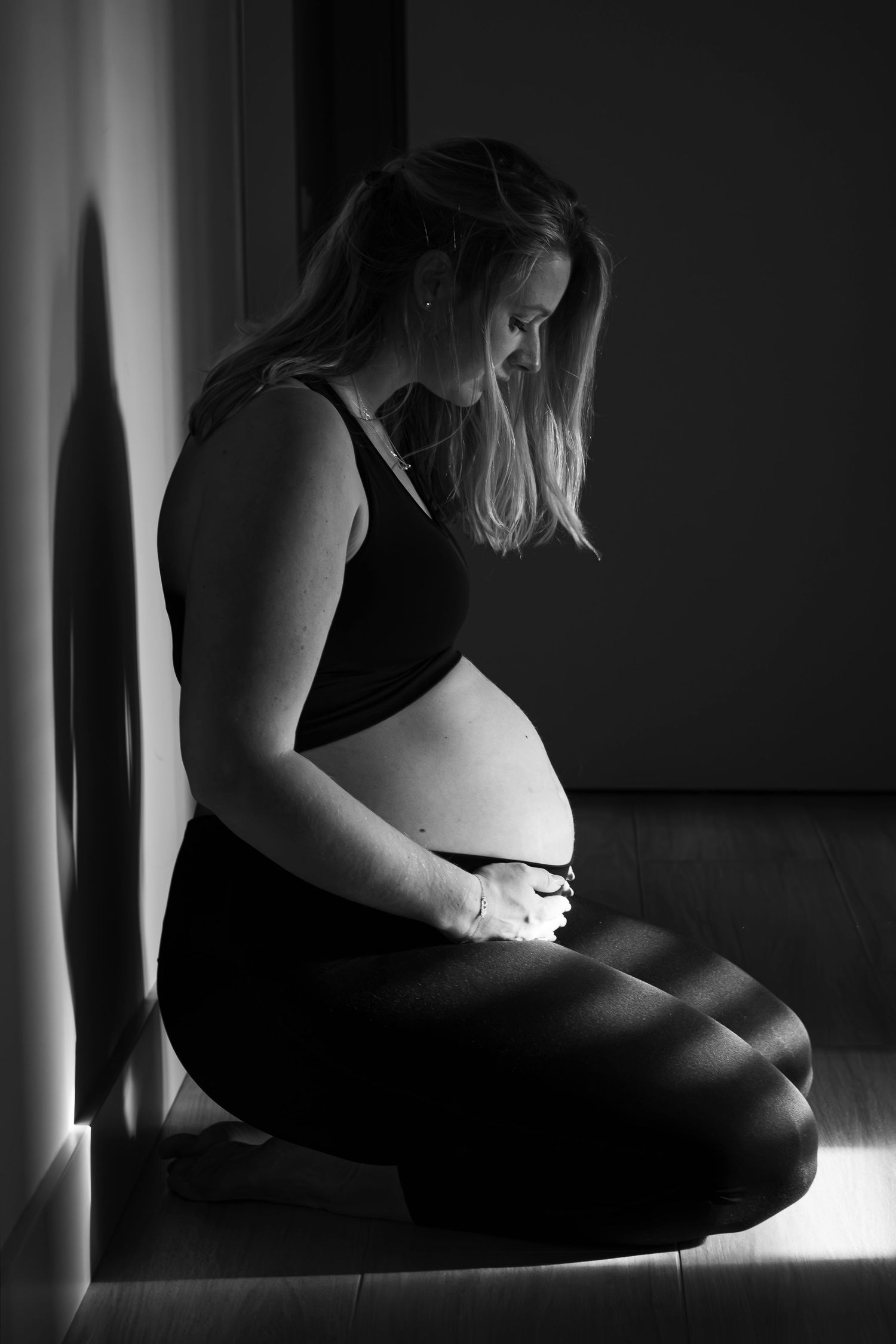 silhouette van zwangere vrouw in het licht op de grond tijdens een zwangerschapsshoot in Zuid-Holland.