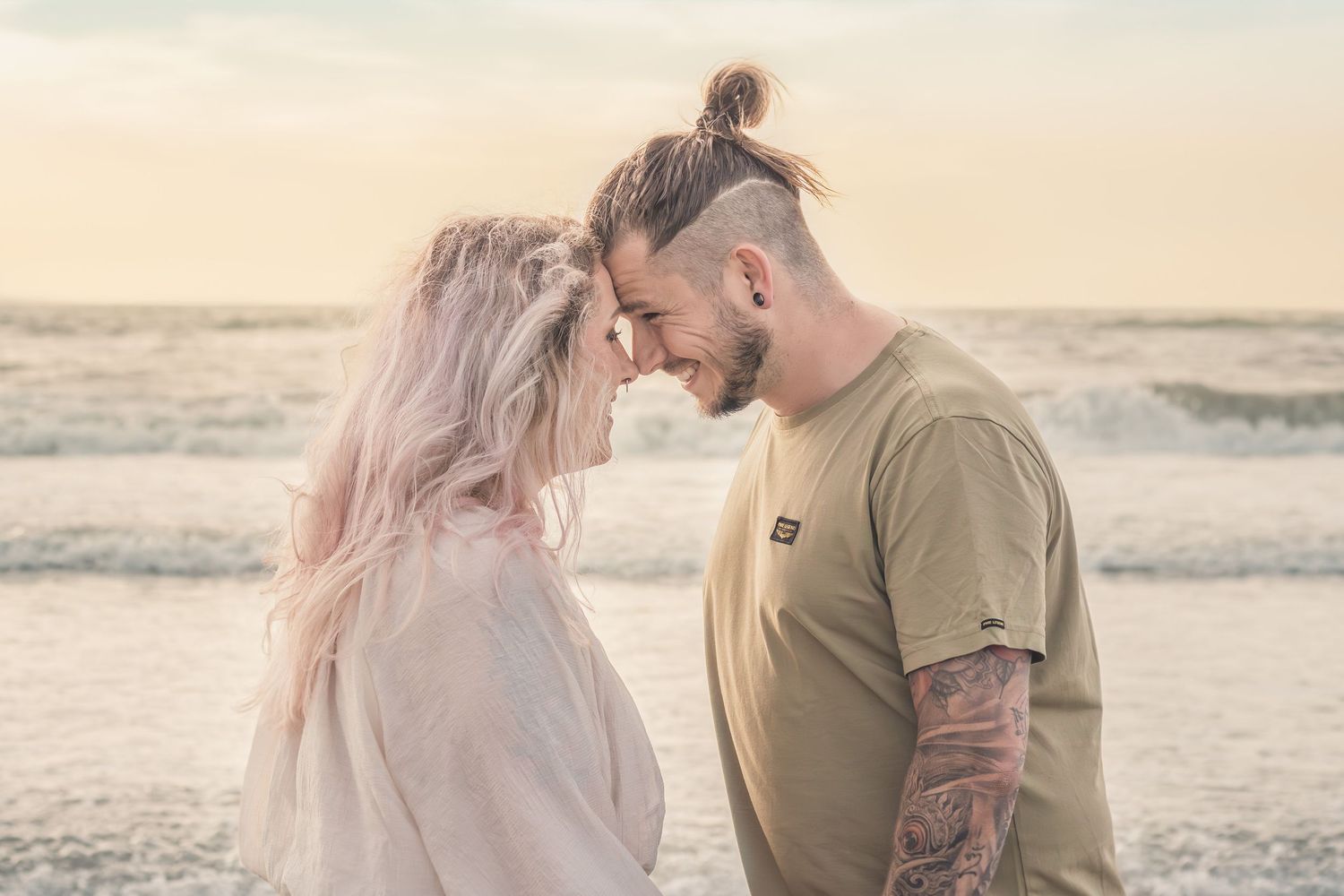 Koppel neus tegen neus op het strand met golden hour tijdens een loveshoot in Zuid-Holland.