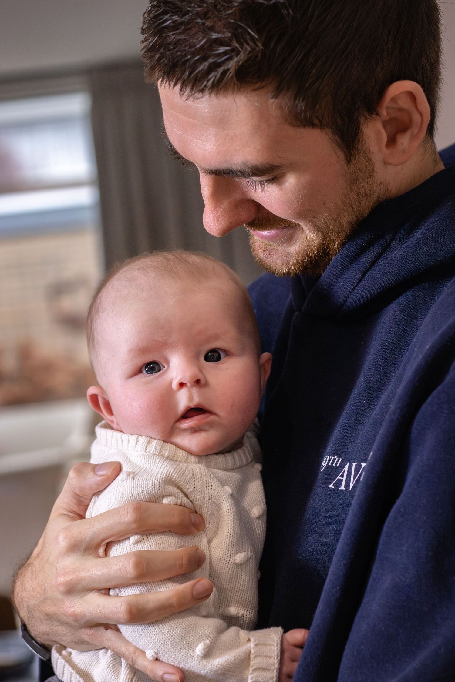 Pasgeboren baby knuffelend met papa tijdens een newbornshoot in Zuid-Holland.