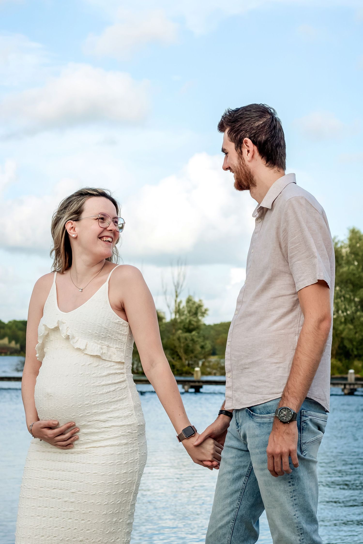 Een zwanger stel die vol liefde elkaar aankijken tijdens een zwangerschapsshoot in Zuid-Holland.
