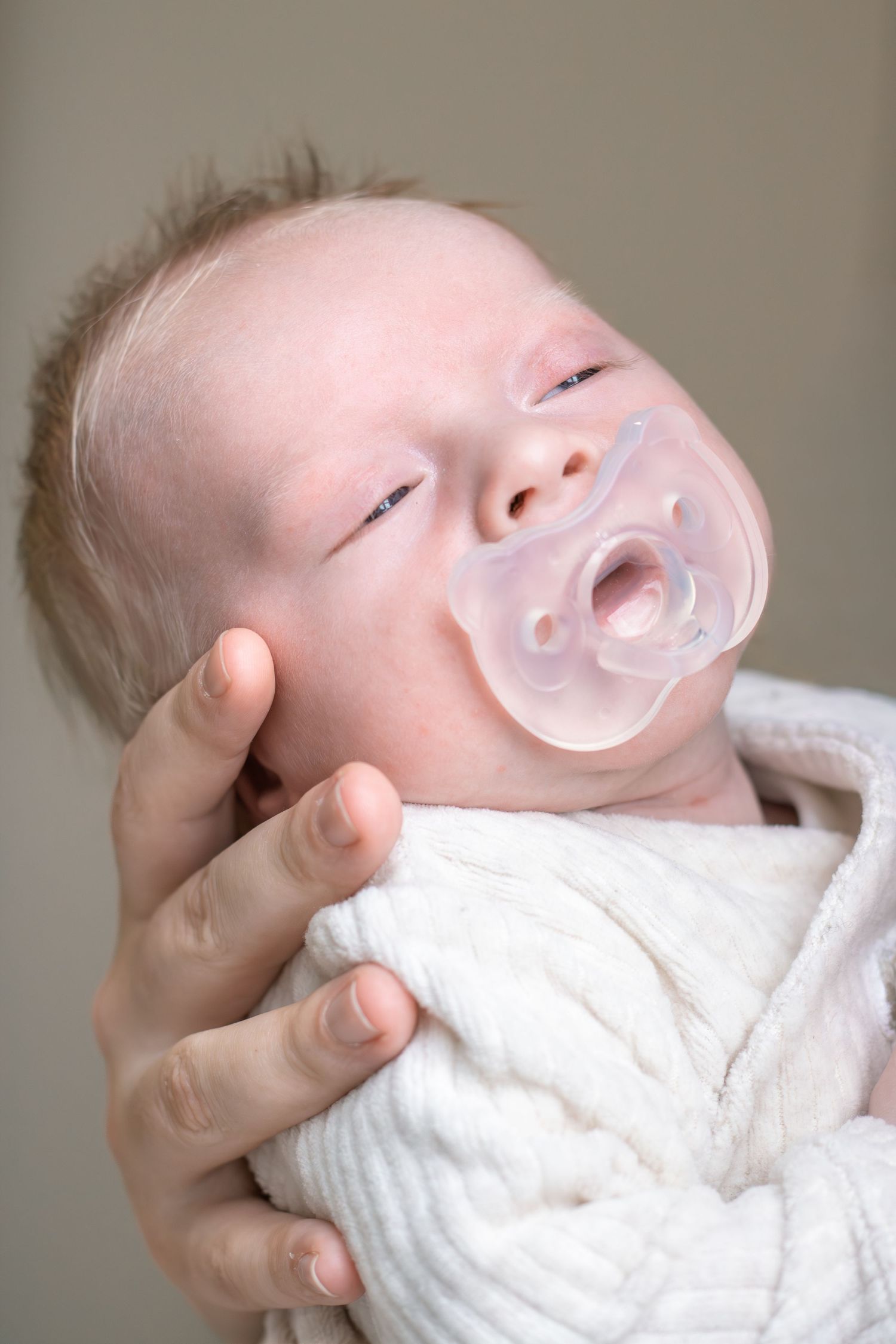 Pasgeboren baby rustig liggend in handen van mama tijdens een newbornshoot in Zuid-Holland.