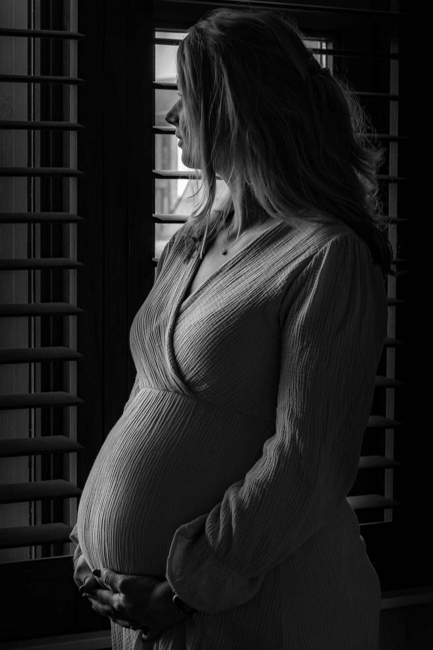 silhouette van zwangere vrouw bij het raam tijdens een zwangerschapsshoot in Zuid-Holland.