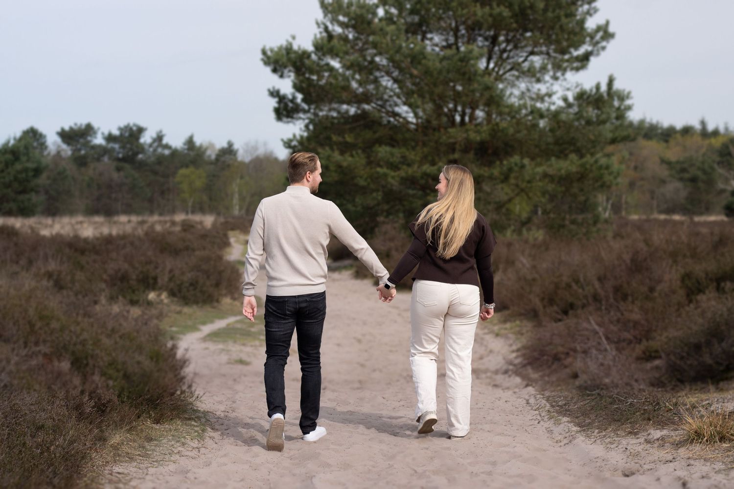 Verliefd stel samen hand in hand wandelend tijdens een loveshoot in Breda.