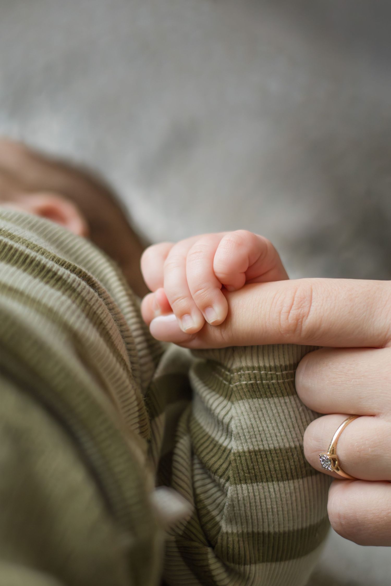 Newborn houdt mama's vinger vast tijdens een newbornshoot in Zuid-Holland.