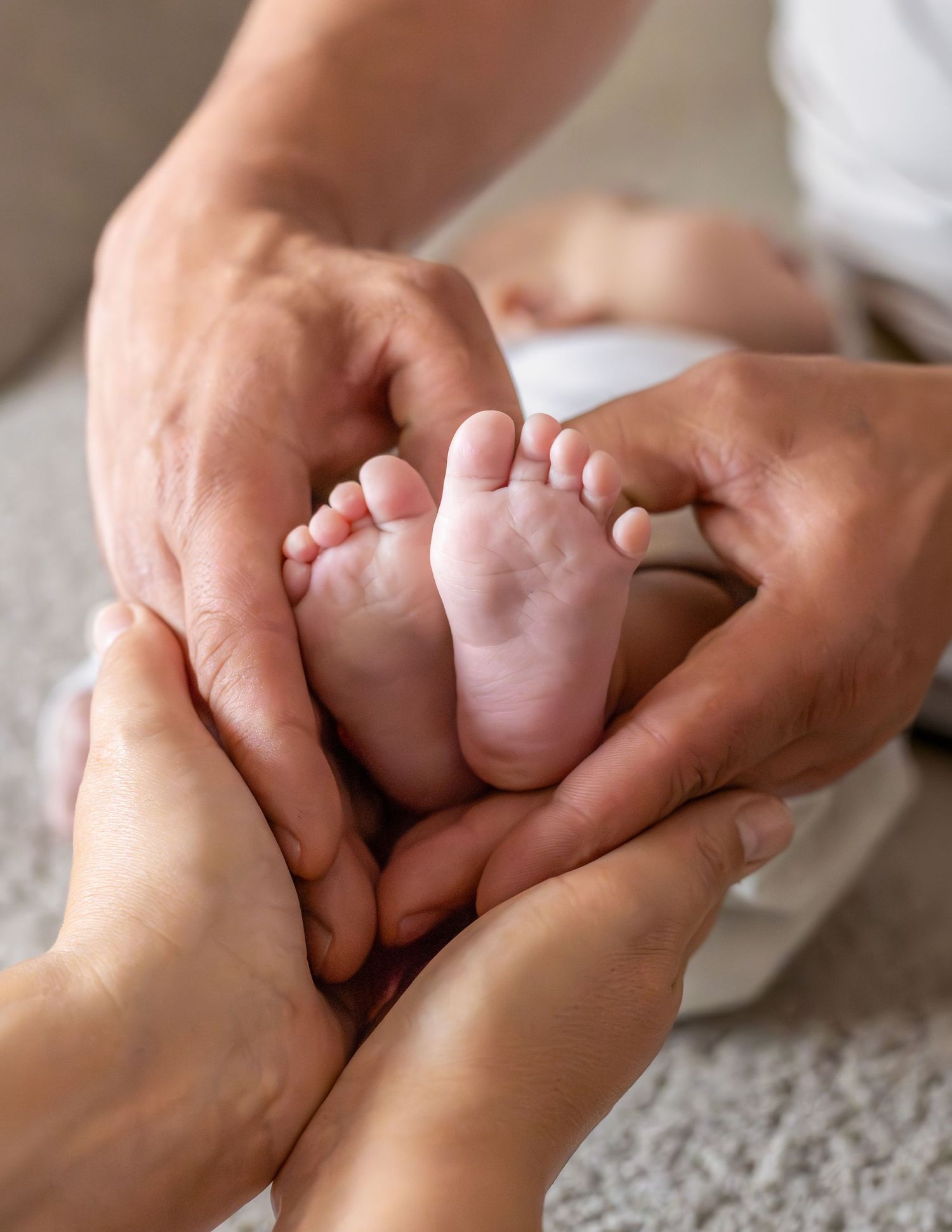 Voetjes van pasgeboren baby in de handen van papa en mama gevormd in een hart tijdens een newbornshoot in Zuid-Holland.