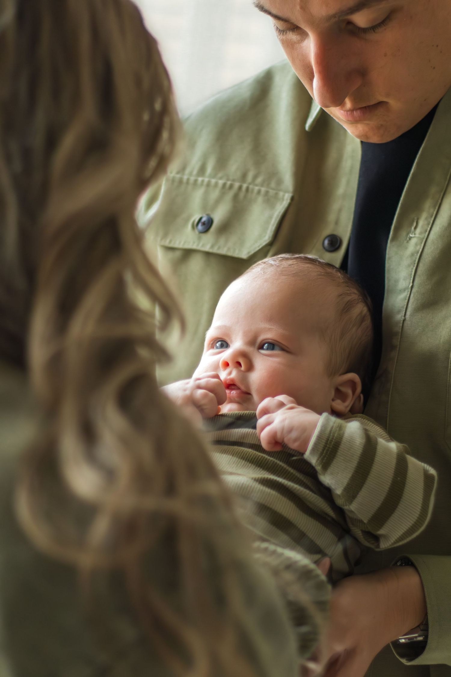 Newborn in handen van papa en mama tijdens een newbornshoot in Zuid-Holland.