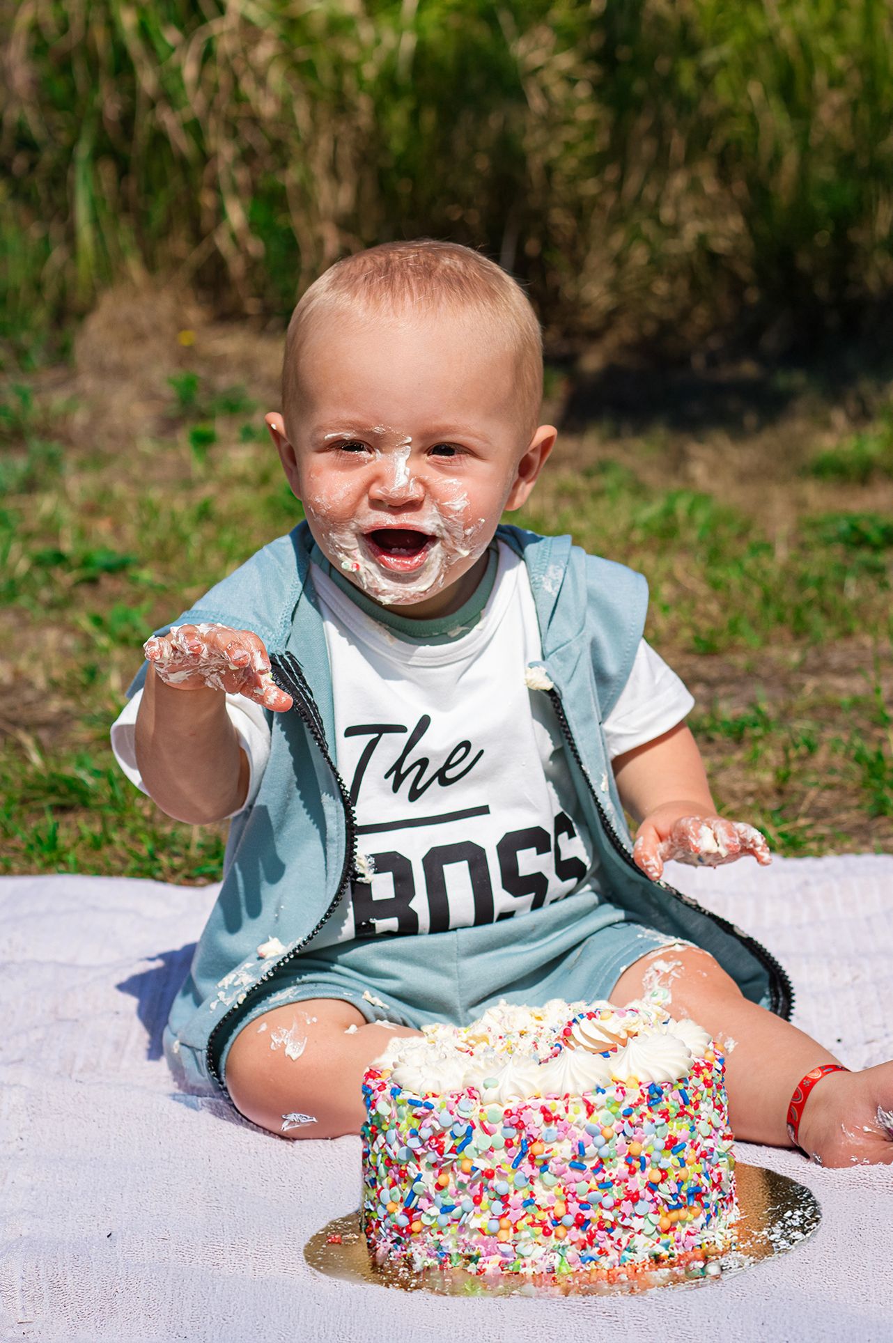 Baby lachend en genieten van het eten van zijn taart tijdens een cakesmashshoot in Breda.
